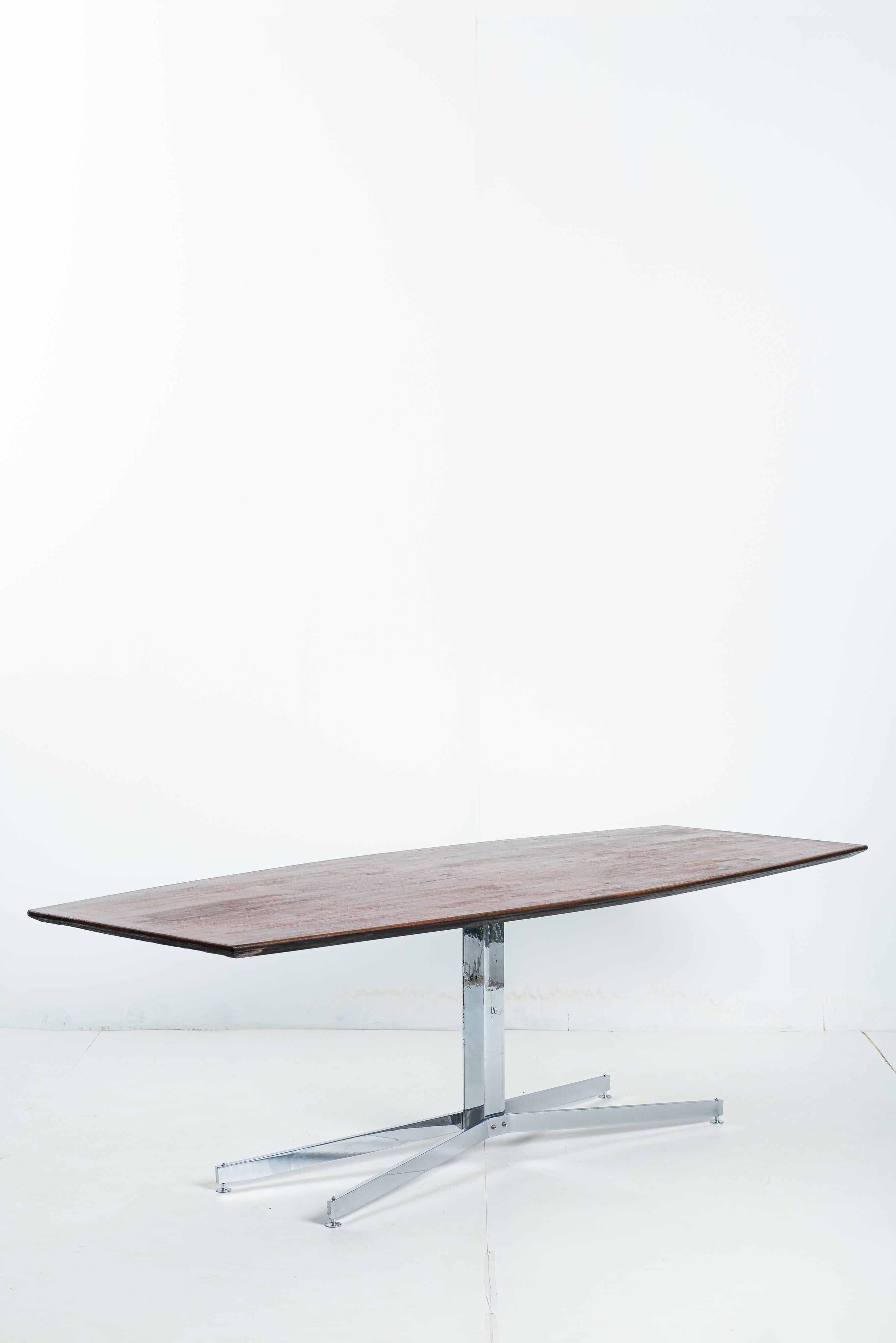 Mid-Century Modern dining or meeting table manufactured by Forma S.A. in the 1950s in Brazil.

The table has a central base in chromed steel with four supports arranged in a cross.
The wood top, with chamfered edges, has a rectangular shape with