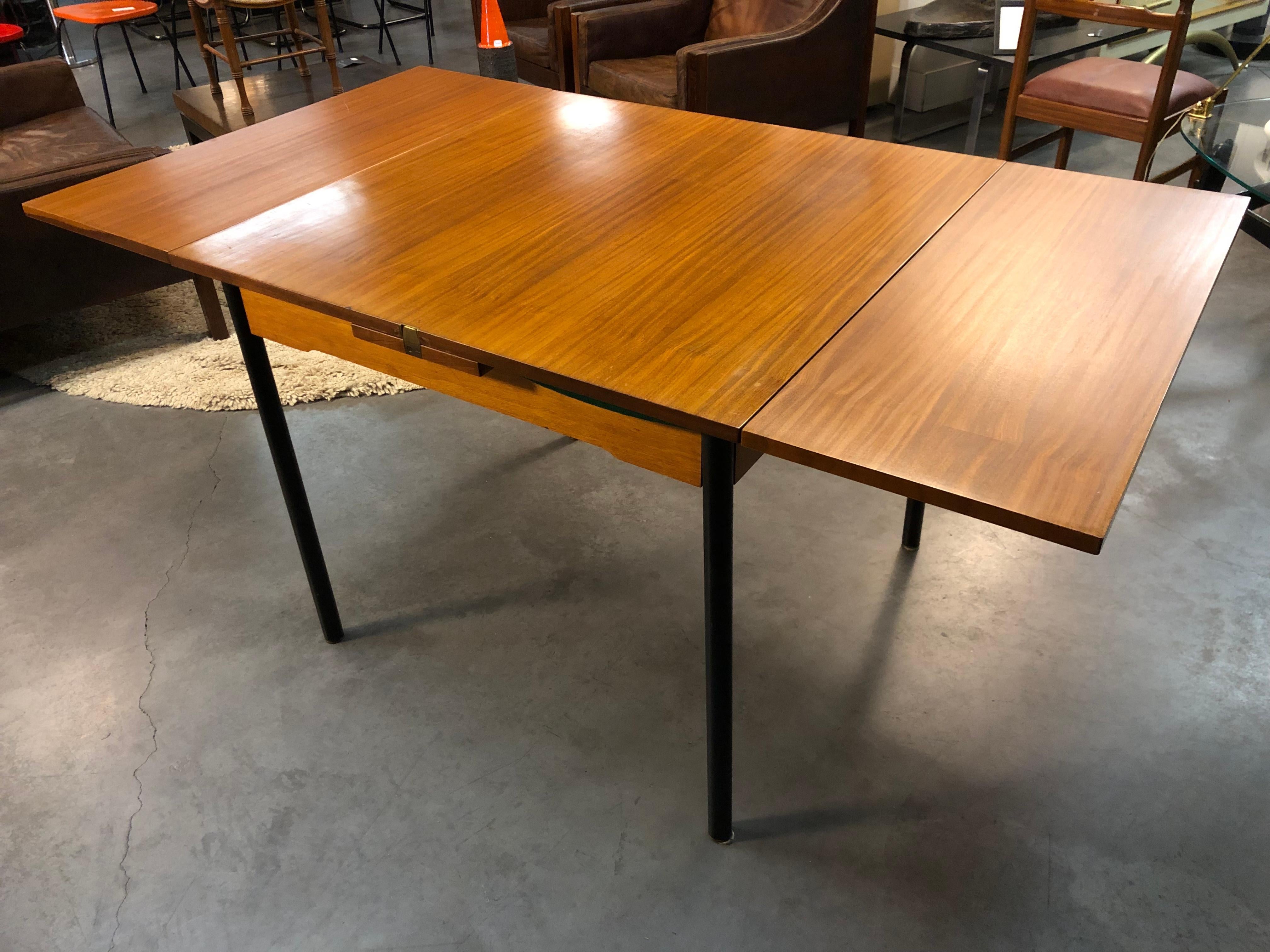 Interesting table that can be either a dining table or a gaming table.
Unknown designer but some details show that it’s a  a reconstruction area furniture  just after the  war very efficient at low budget. 
So some kind of typicalities that can