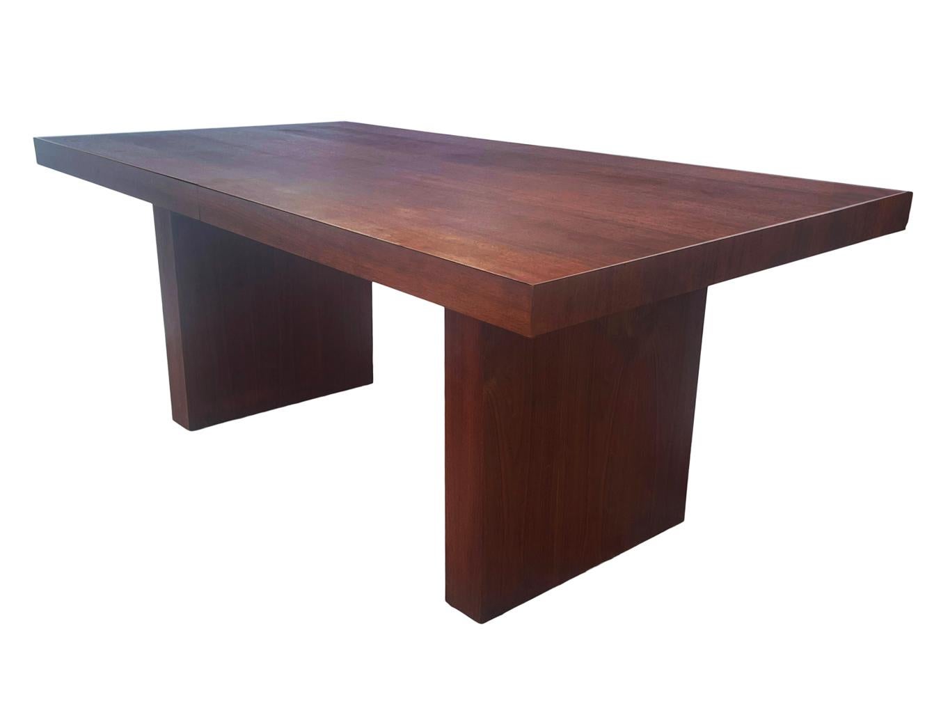 A clean line dining table by Arthur Umanoff circa 1960's. It features beautiful walnut wood construction. It comes with two 18 inch leaves not shown. Maximum length is 108 inches with leaves. Very clean and ready to use condition.