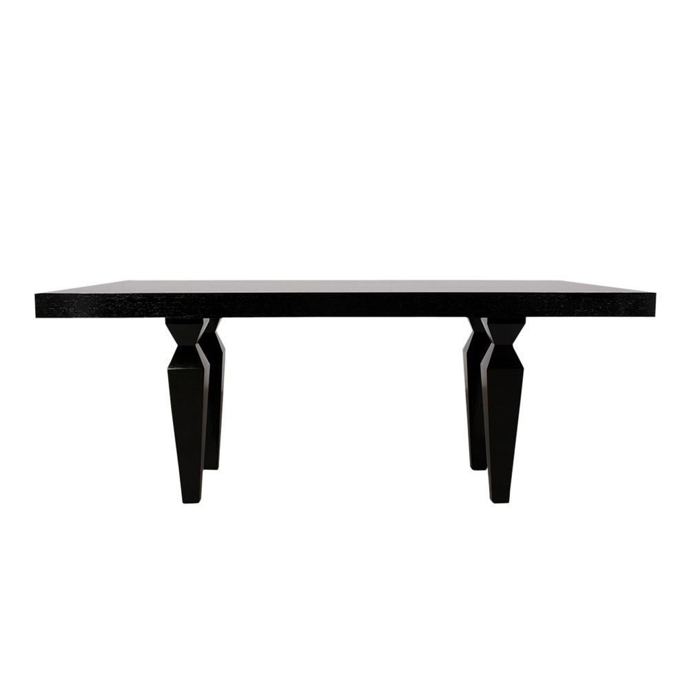 An extraordinary 1960s modern dining table hand-crafted out of beech wood has been professionally restored features rich ebonized color with a lacquered finish. The table has a rectangular top with pull-out supports for two extra leaves, rests on