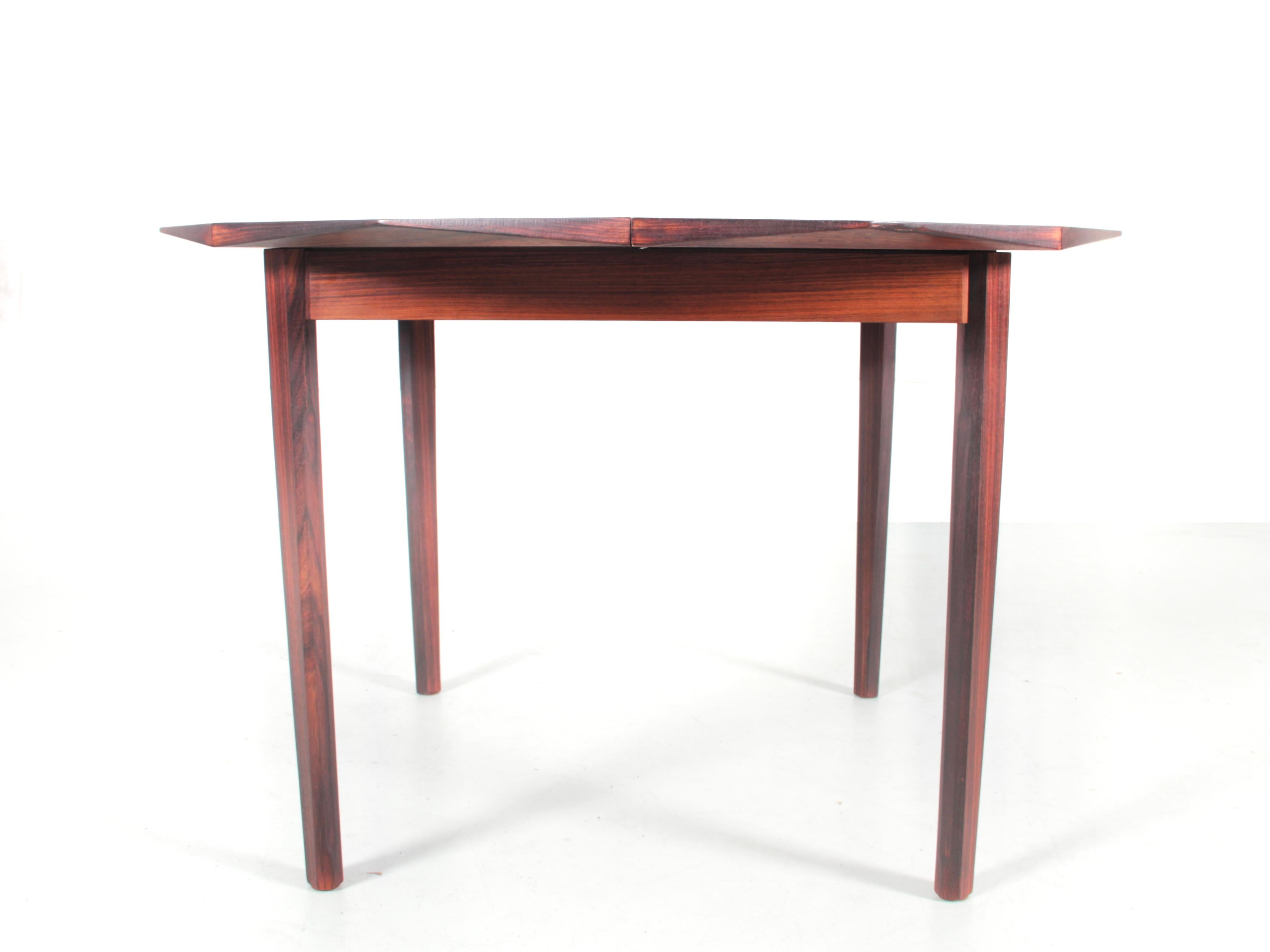 Table de salle à manger ronde en bois de rose. Extensible pour accueillir 4 à 6 personnes. 1 extension intérieure.




