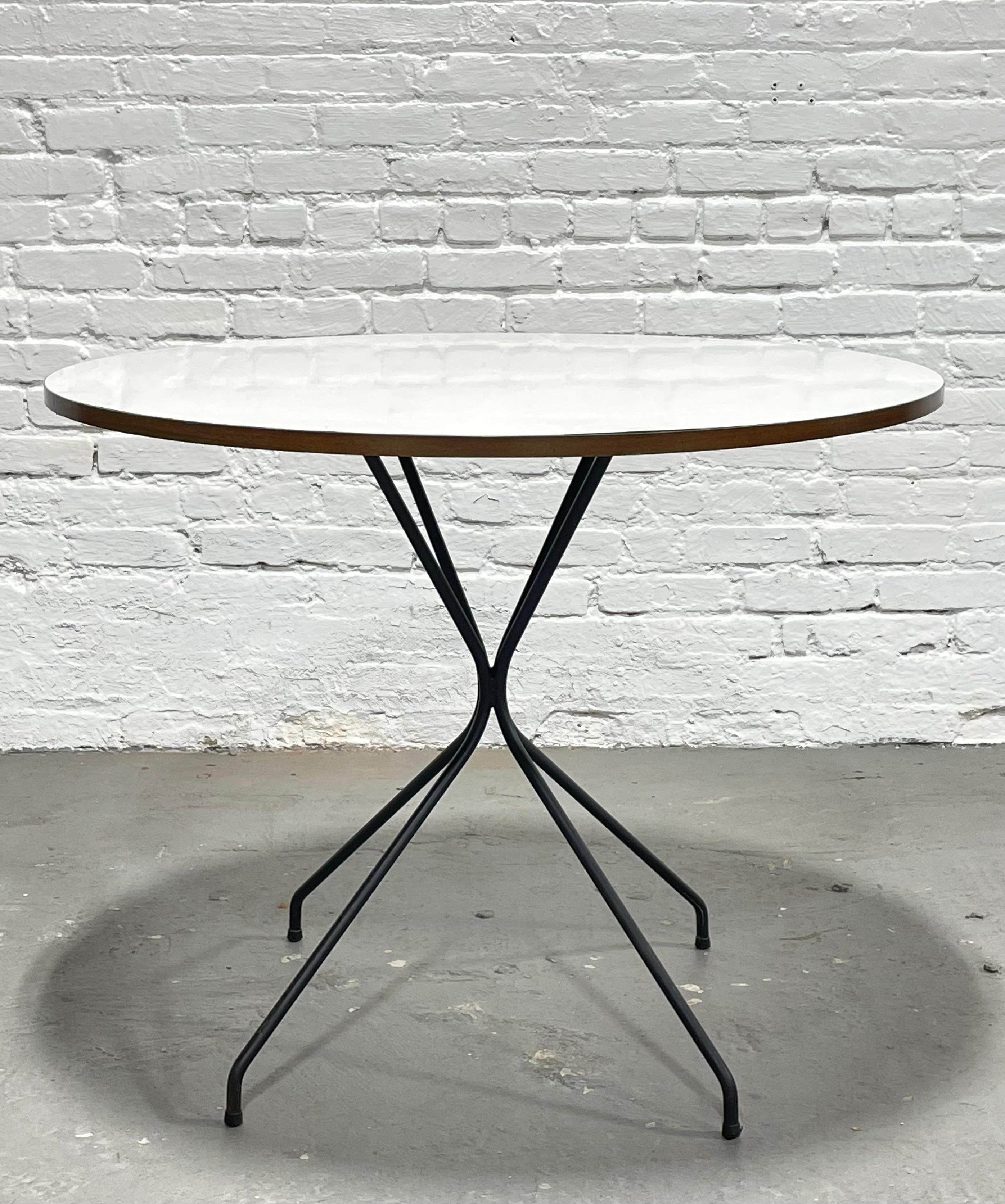 Mid Century Modern Dining Table in the style of Clifford Pascoe, c. 1960's. Perfectly sized for smaller spaces featuring a solid + sturdy black iron base, synched in the center for an hourglass look. Incredible and rare table, perfect for smaller
