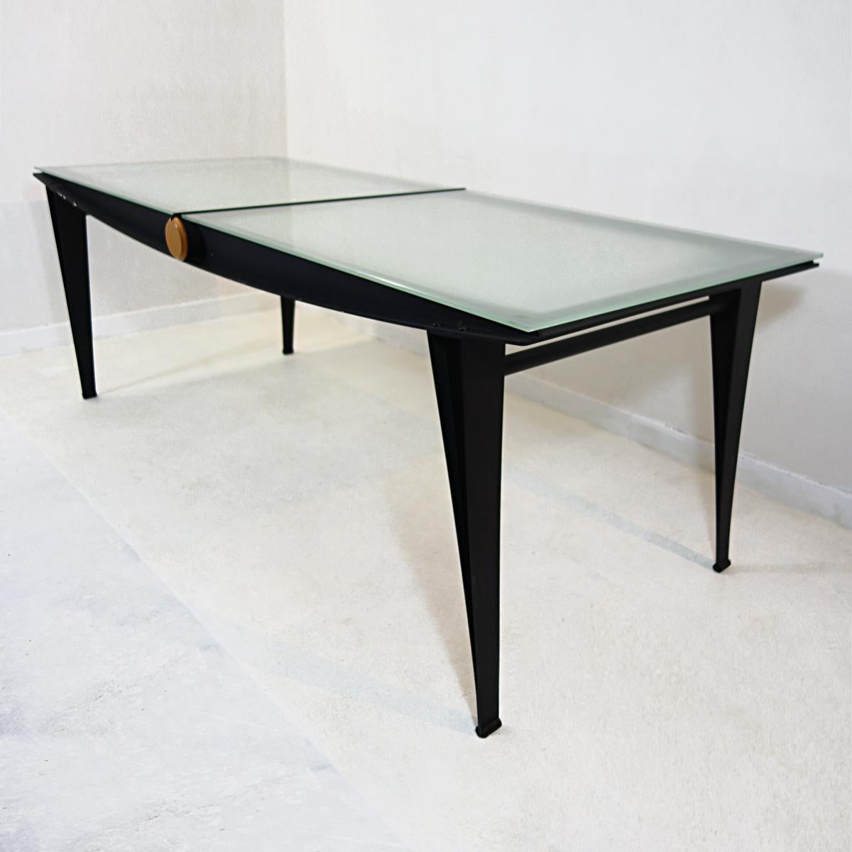 Very elegant dining table that makes a clear architectural statement with its wonderfully detailed black steel frame. The top consists of two glass plates that have been sandblasted.
A cute detail is the round drawer made of wood that made be used