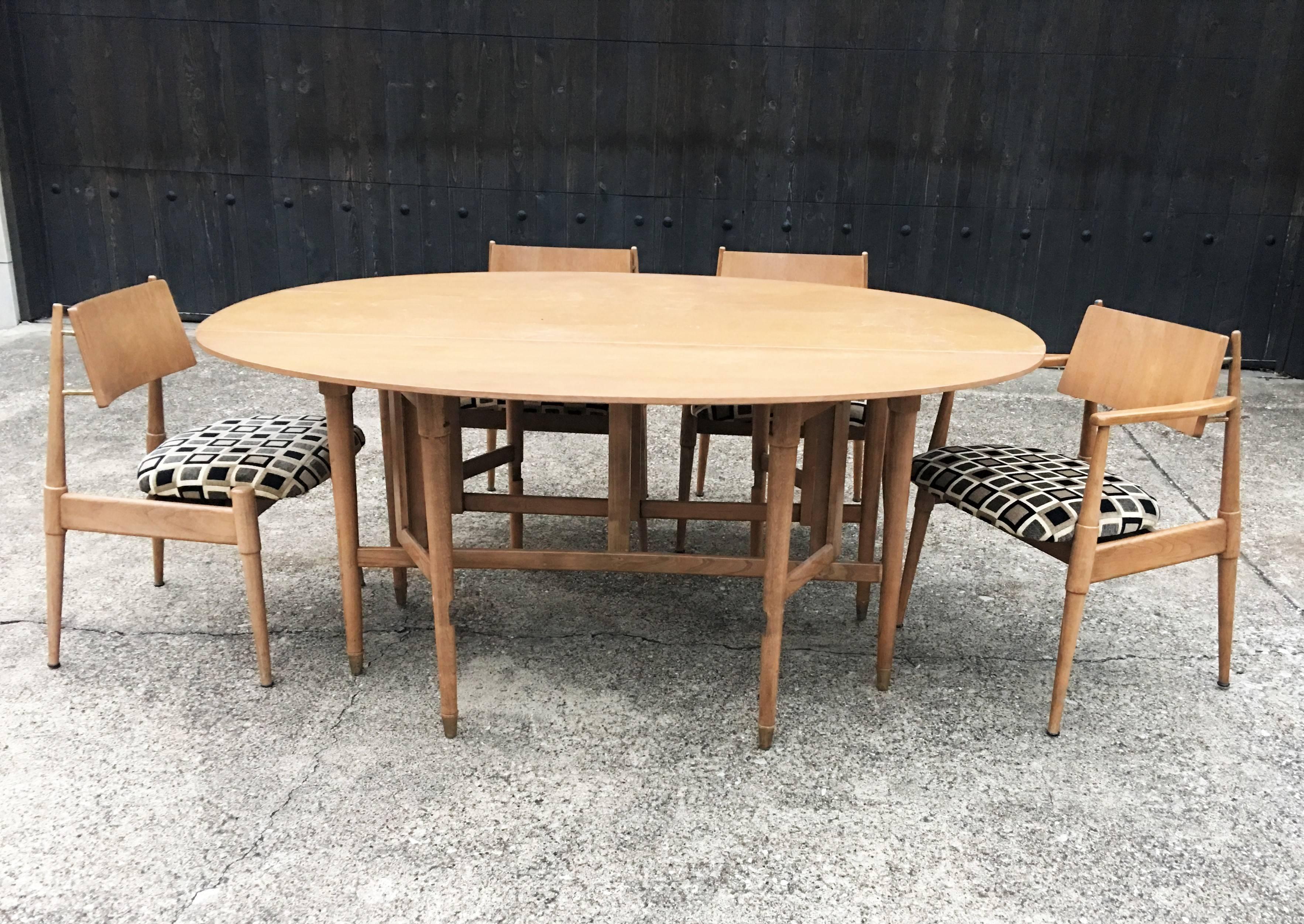 This unique exquisite blonde maple dining set features a dining table, paired with six intricately designed matching chairs. Has one captain chair and five regular. A masterful blend of style and comfort this midcentury set is perfect for kitchen or