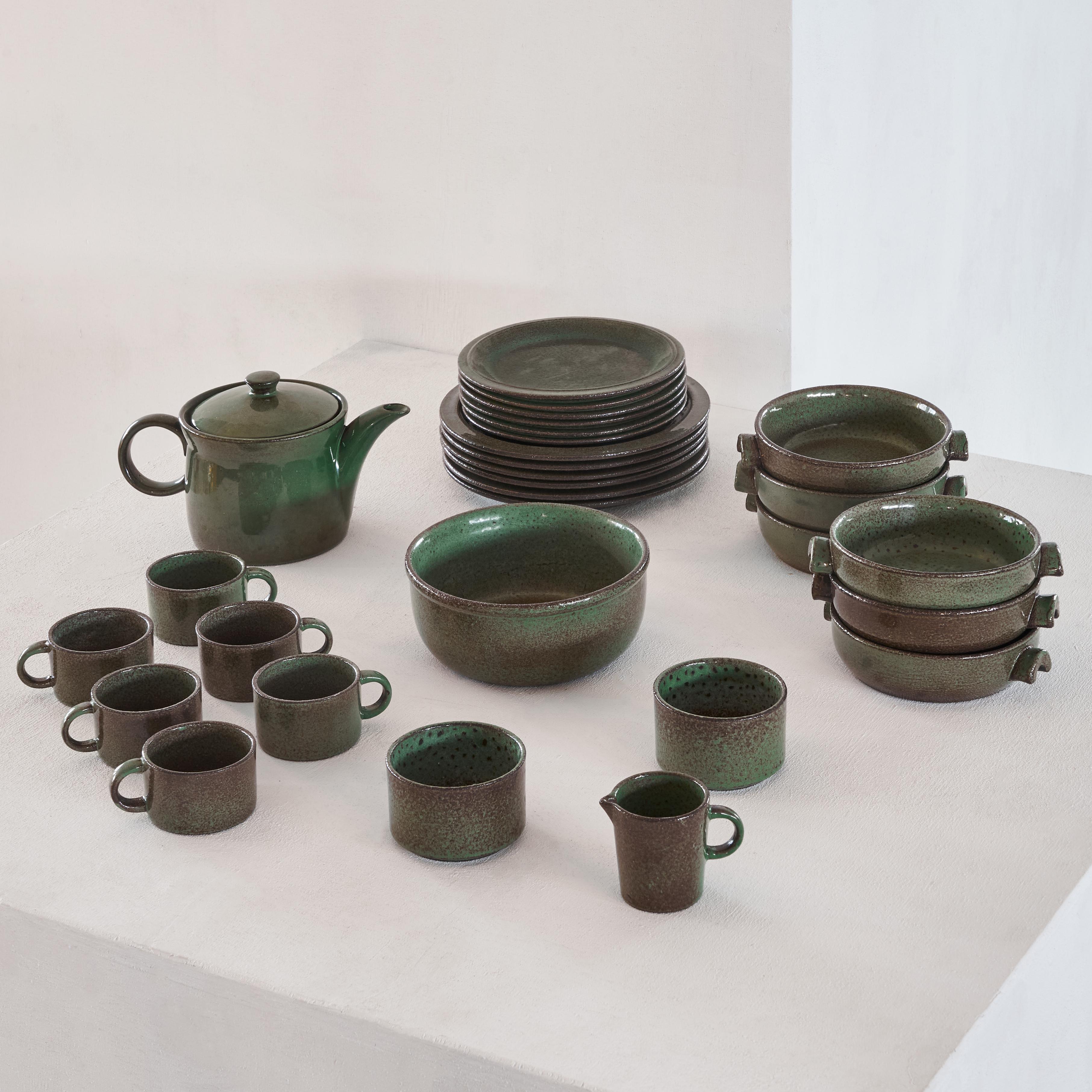 Wonderful Mid-Century Modern dinnerware set in pottery and green and brown glaze. The set contains 30 pieces and could be used for 6 persons. 

This dinnerware set is a joy for your eyes, since the clear shapes and the glazing are very