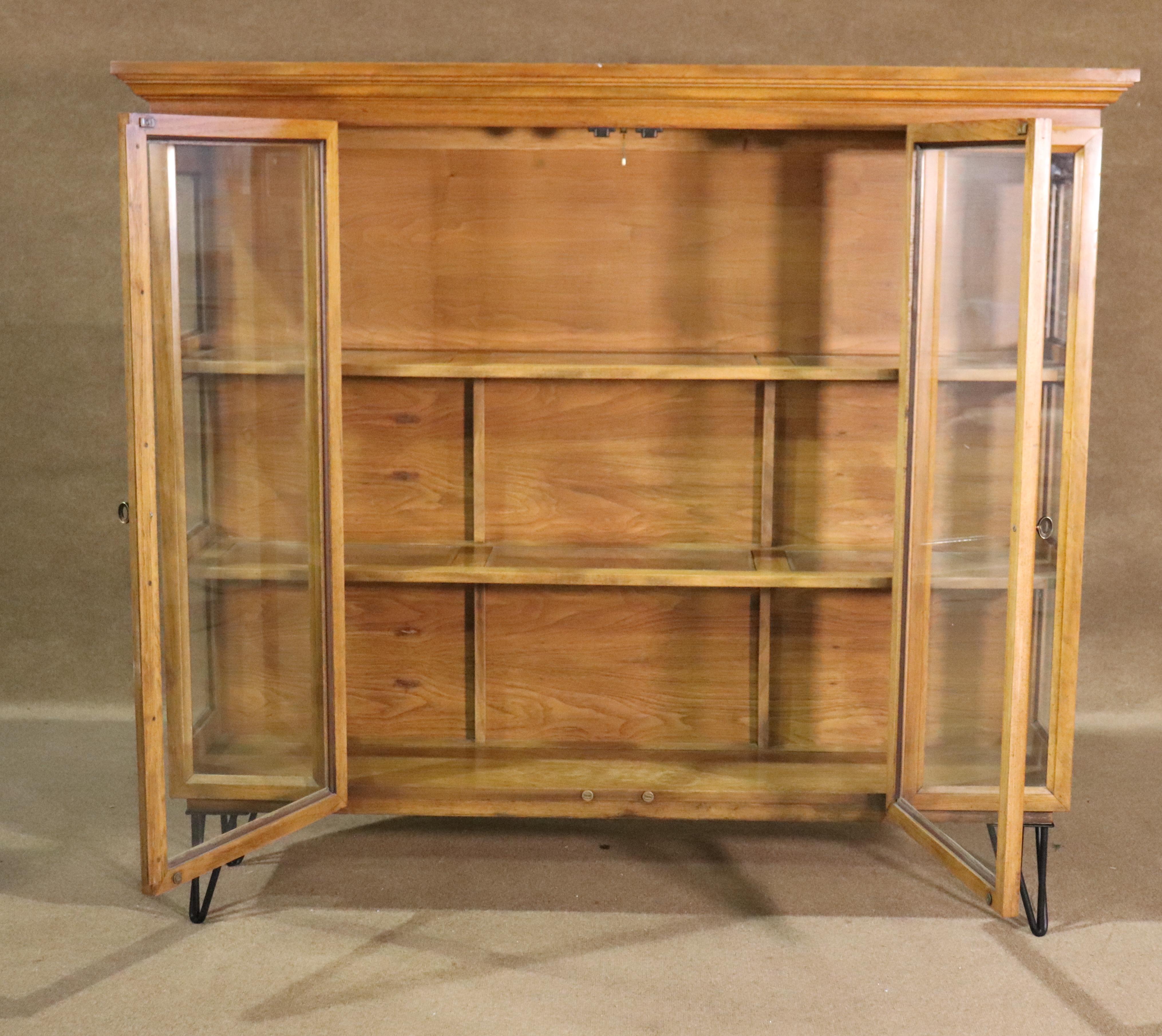 Vintage American made cabinet with hair pin iron legs. Three sides of glass for display, shelves with glass, two large doors. 
Please confirm location NY or NJ