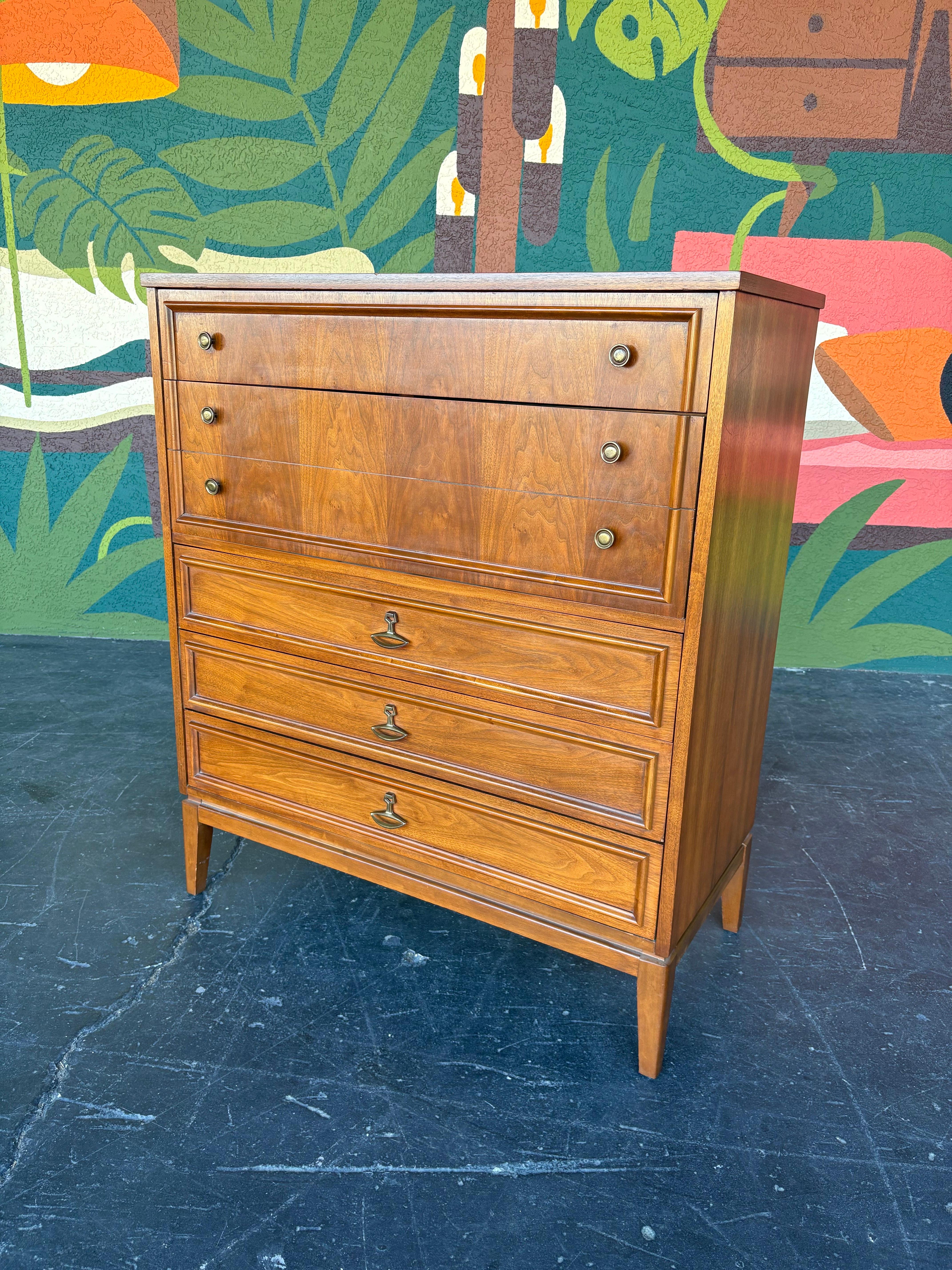 1960’s Mid Century Modern Walnut Tallboy Dresser. 6 drawers total with lovely walnut book matched veneers and contrasting trim, accented with brass pulls. Overall great original vintage condition, some typical light scuffs, scratches and dings from