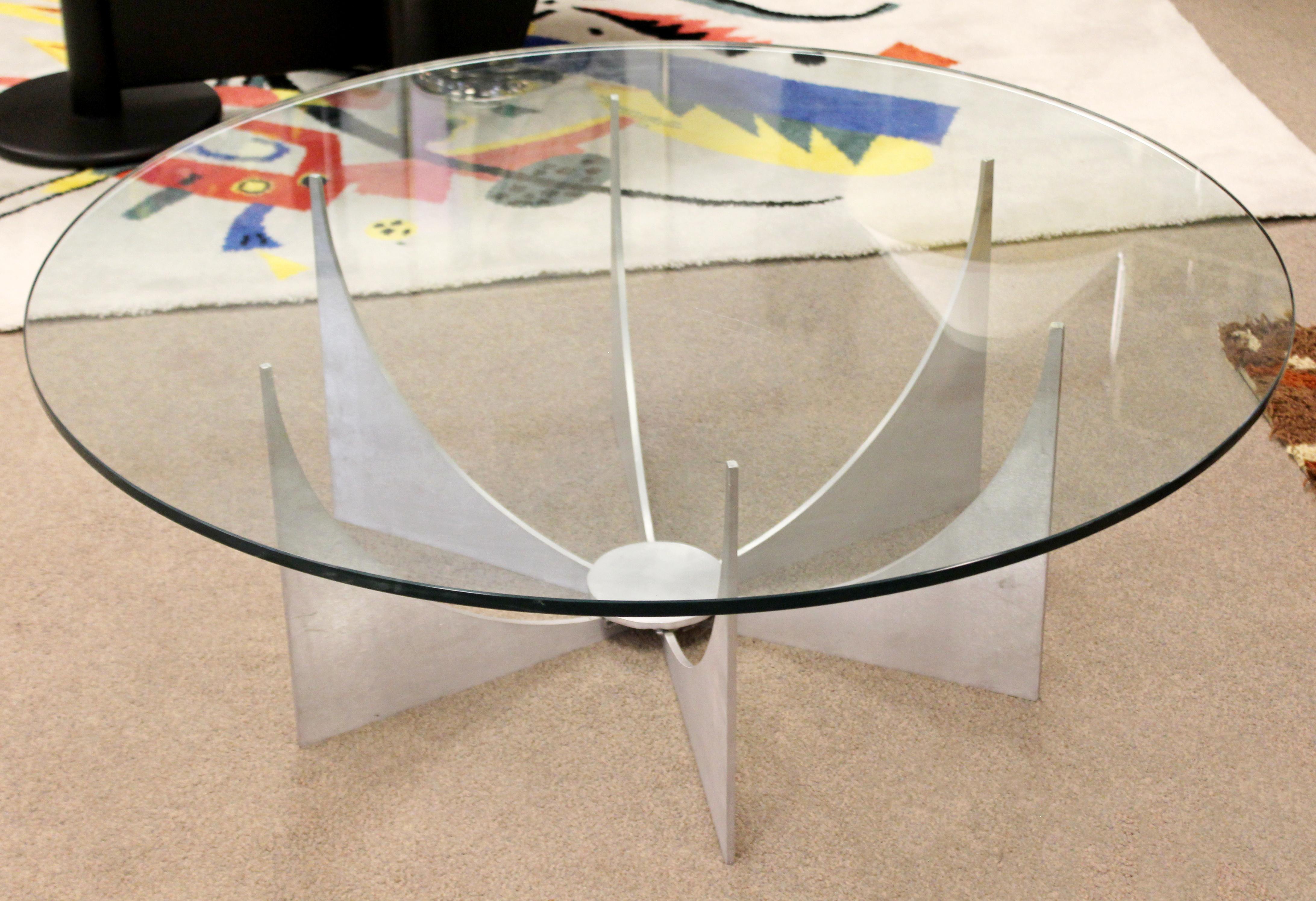 For your consideration is a Minimalist, round coffee table, made of brushed aluminum and with a glass top, by Donald Drumm, circa 1970s. In excellent condition. The dimensions are 44
