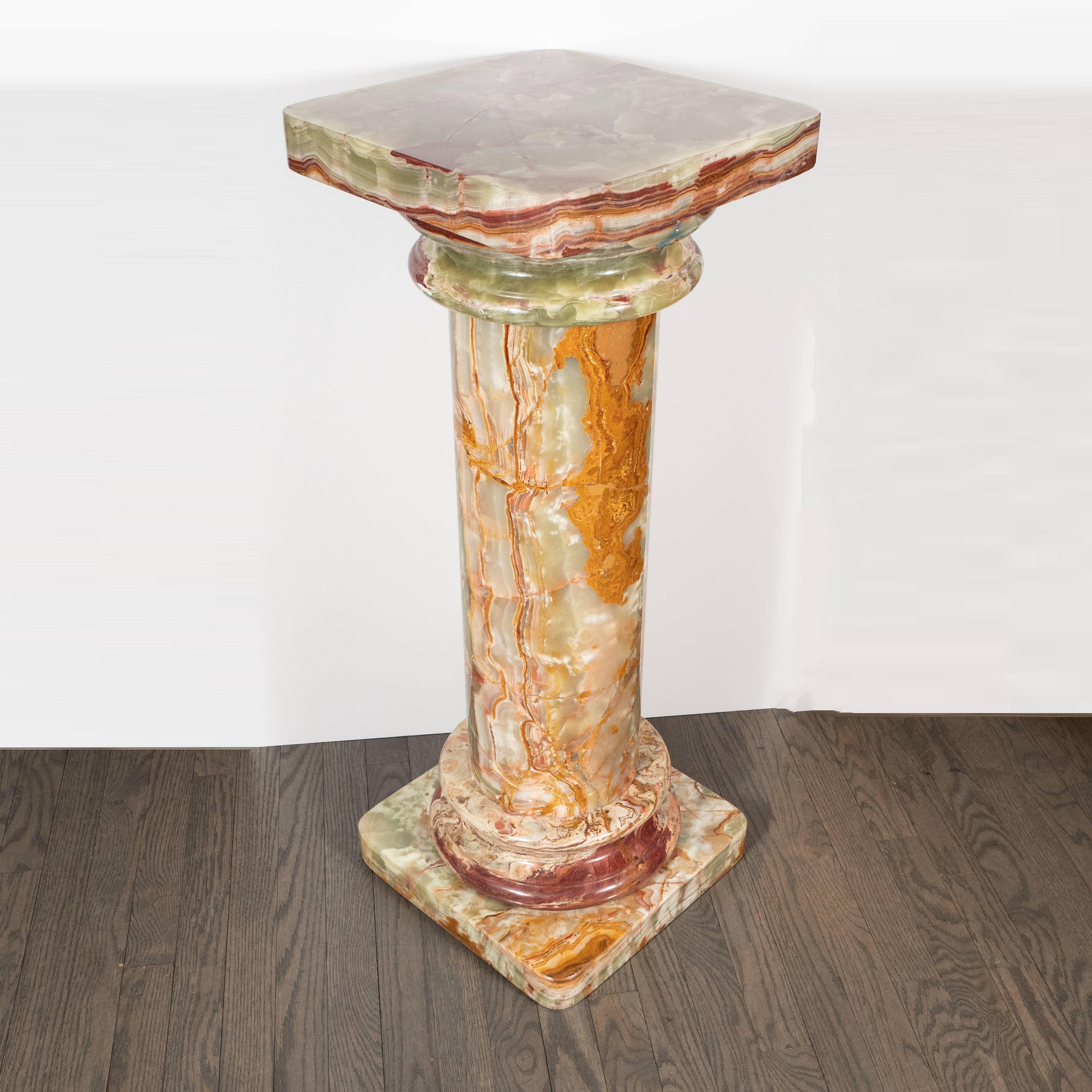 This stunning Doric column pedestal was realized in Italy, circa 1950. It features a square base with rounded corners and a matching top, and a cylindrical body framed on either side by ringed embellishments. The variegated Italian marble offers a