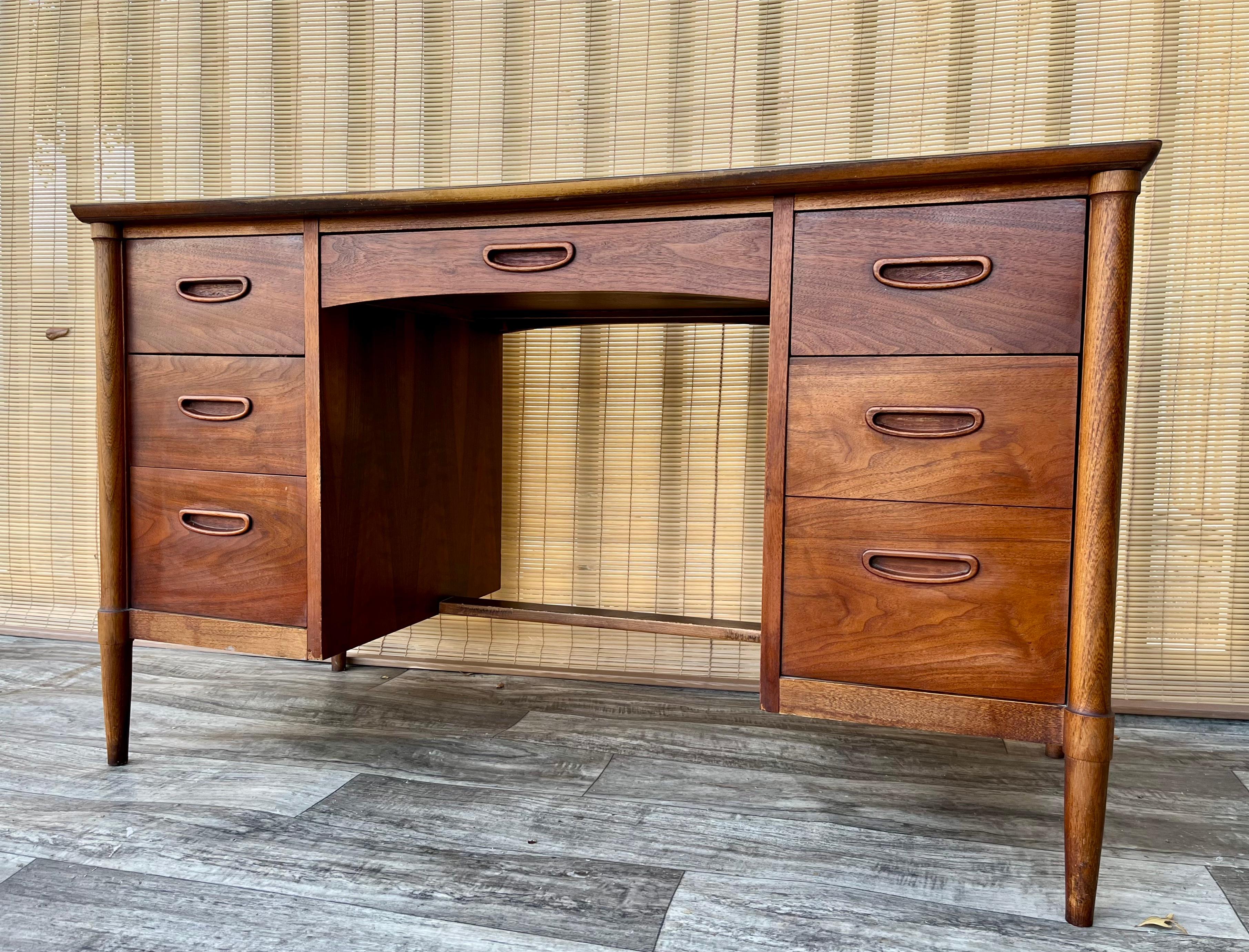 Vintage Mid Century Modern Double-Sided Desk by Lane Furniture. Circa. 1960s 
Features a beautiful walnut wood grain, a quintessential Mid Century Modern Design, a faux woodgrain laminated top, and six drawers with sculpted hand pulls for plenty of