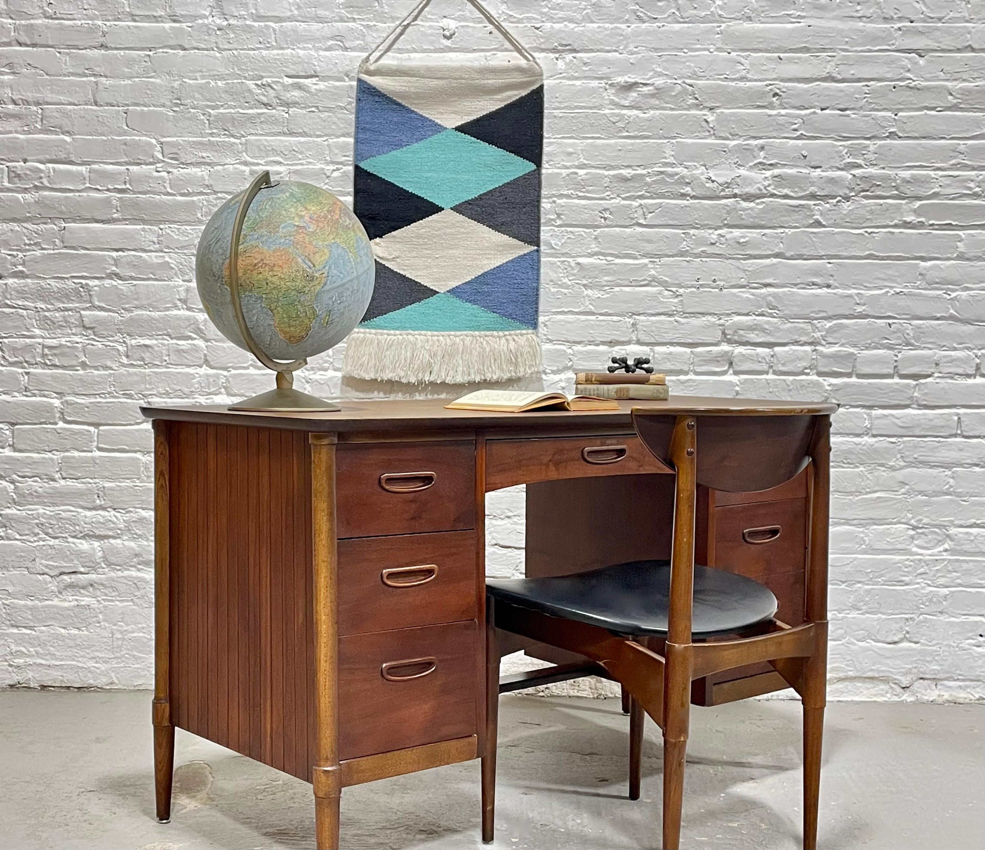 Mid Century Modern Walnut Desk by Lane Furniture, featuring a total of six drawers, including a file cabinet, for plenty of storage.  This desk is highlighted by sculpted hand pulls and a laminate woodgrain tabletop, perfect for withstanding the