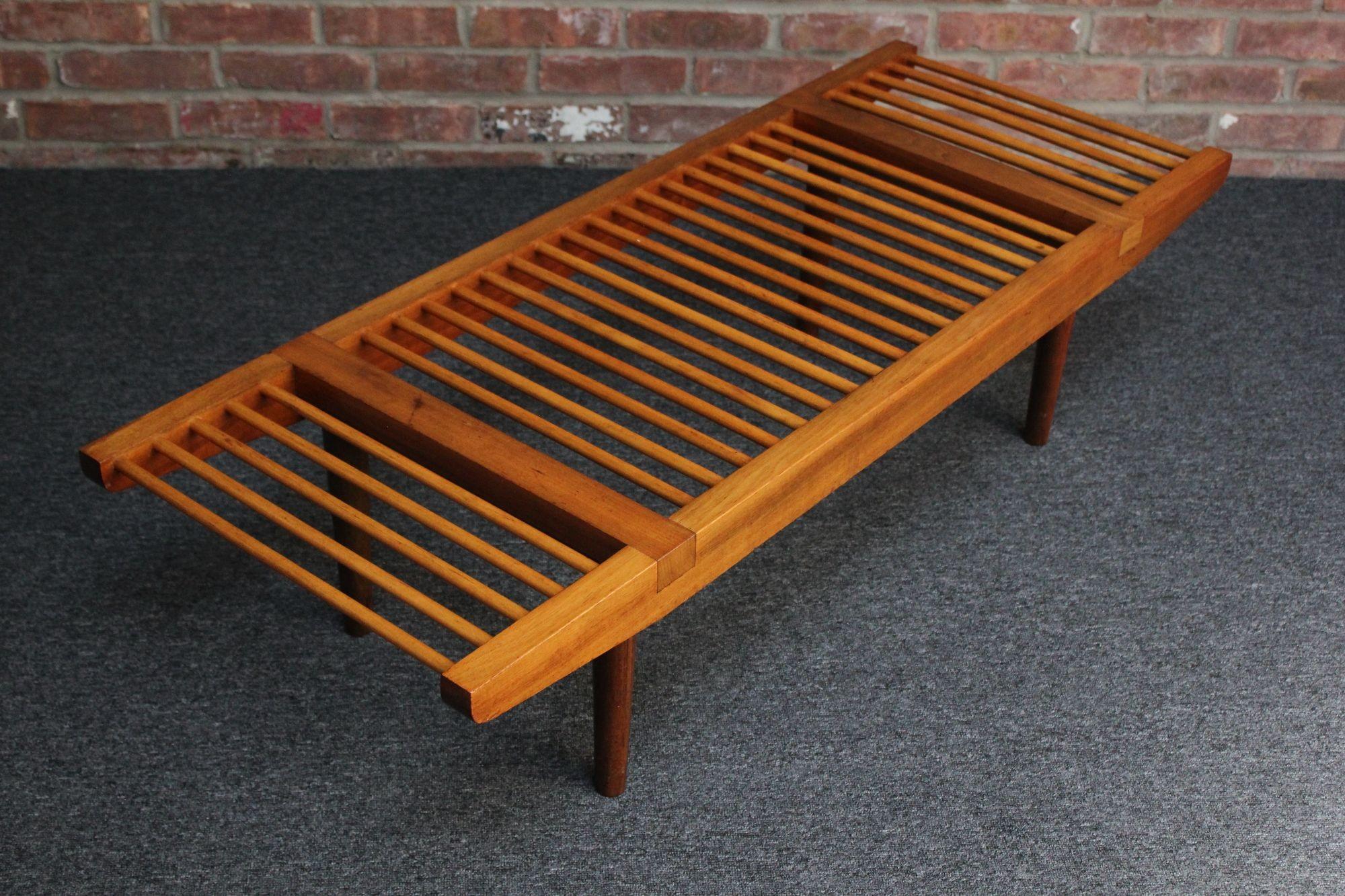 Short bench/coffee table designed by Milo Baughman for Glenn of California (ca. 1950s, USA). Composed of a gently tapered walnut frame and turned legs supported by two sets of spacers. Birch dowels create the slatted surface, adding a nice light