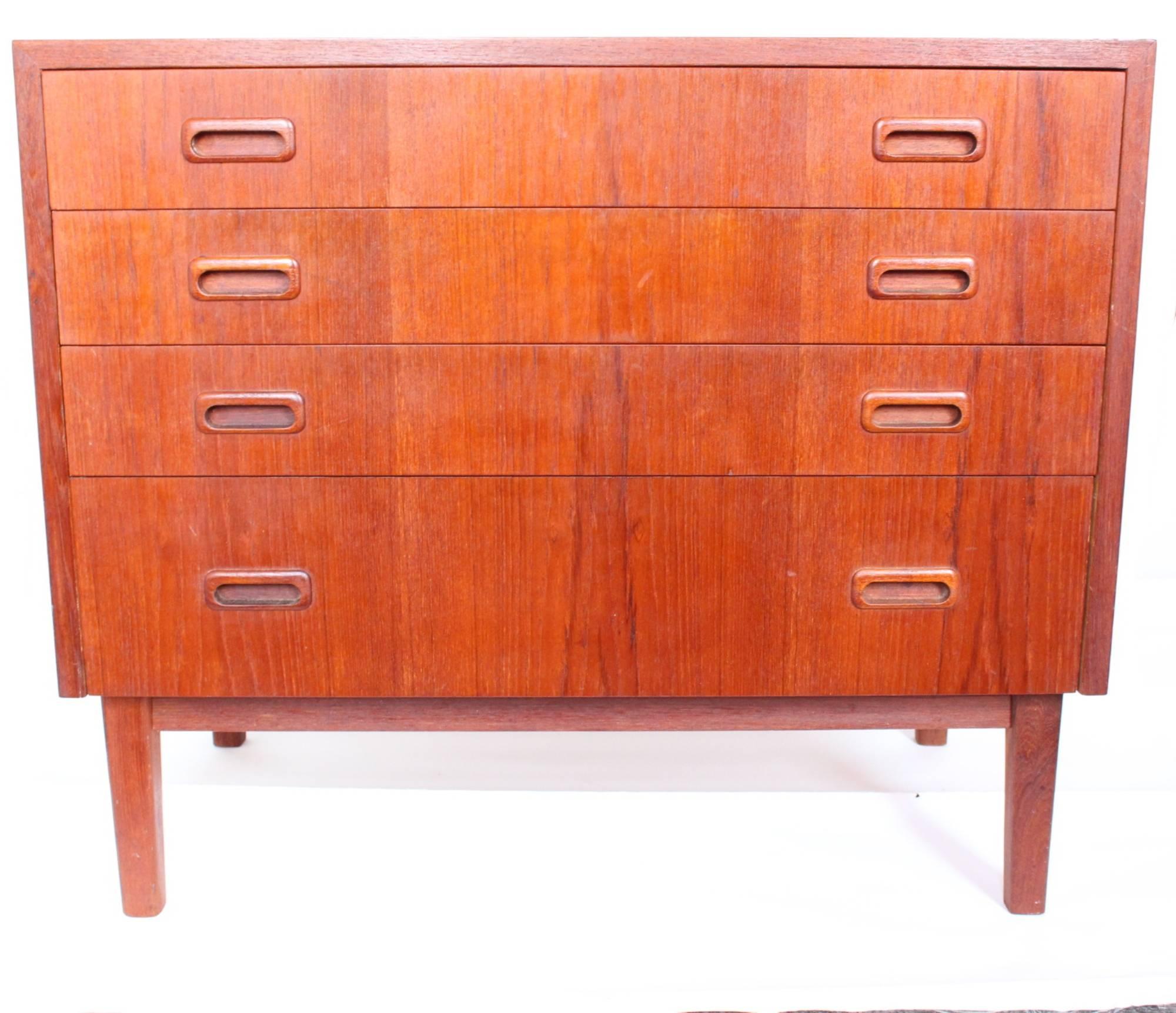 Mid-Century Modern dresser and chest of drawers crafted in teak wood. The dresser features five drawers, all but one with a depth up to 6