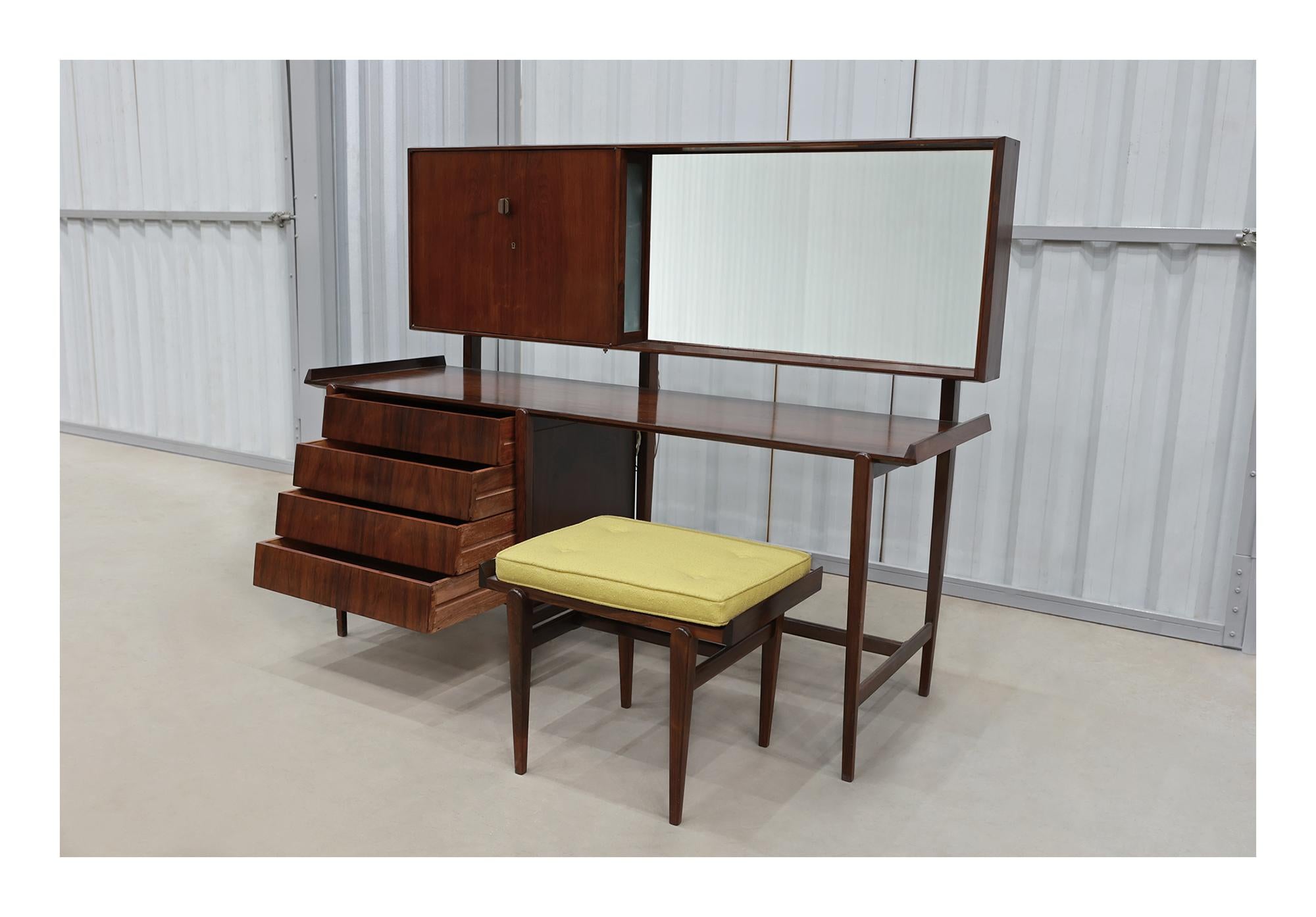 This set comes with a stool and a dresser that has a mirror, four drawers, and one cabinet. The light in the dresser has been rewired and works perfectly. The set is made with Brazilian hardwood and it has a beautiful color and pattern to it. The