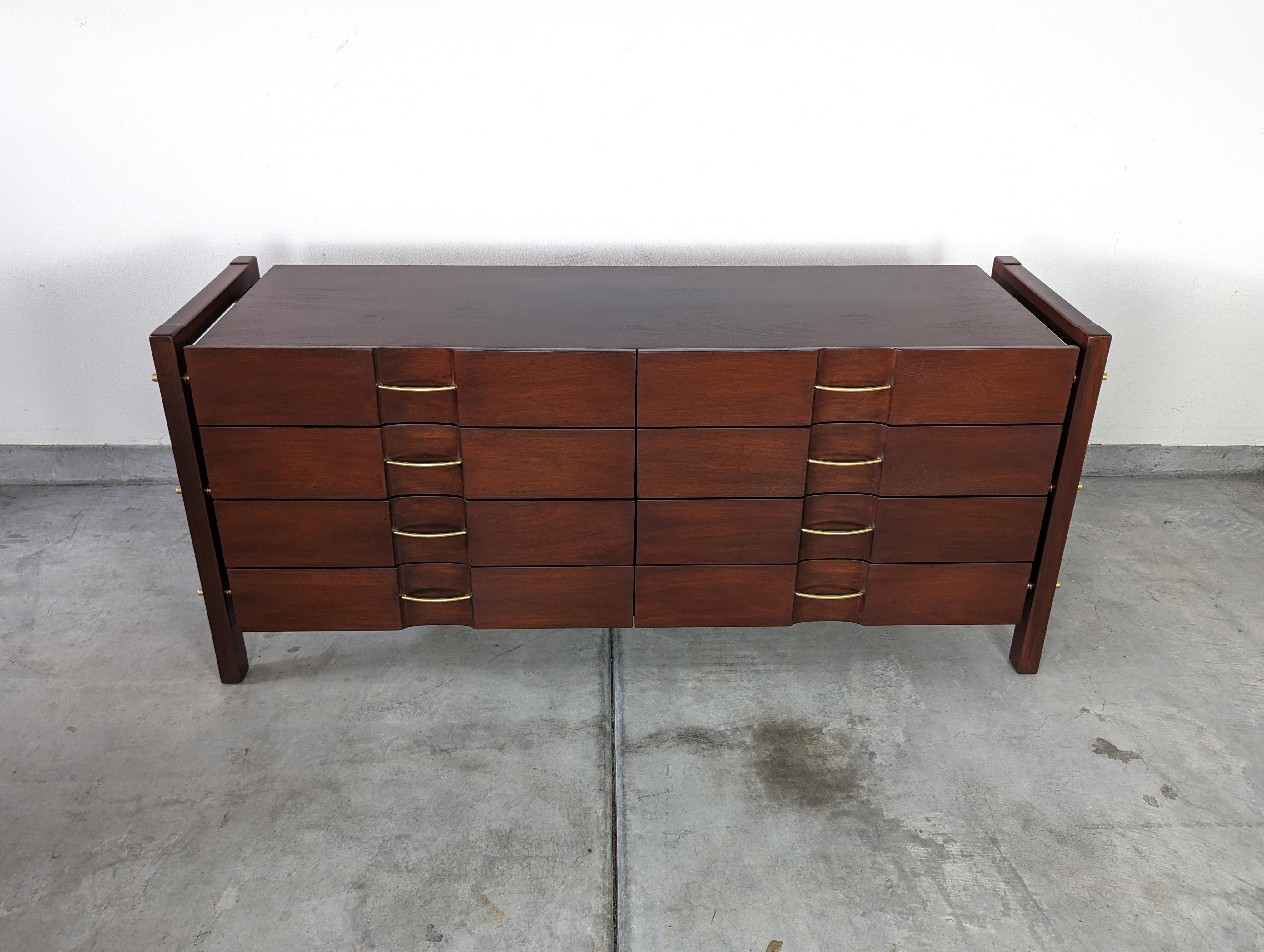 For sale is a spectacular mid-century dresser designed by the renowned Edmond J. Spence and manufactured by the esteemed Industria Mueblera of Mexico. This unique piece showcases the exceptional quality and timeless elegance of Spence's designs and