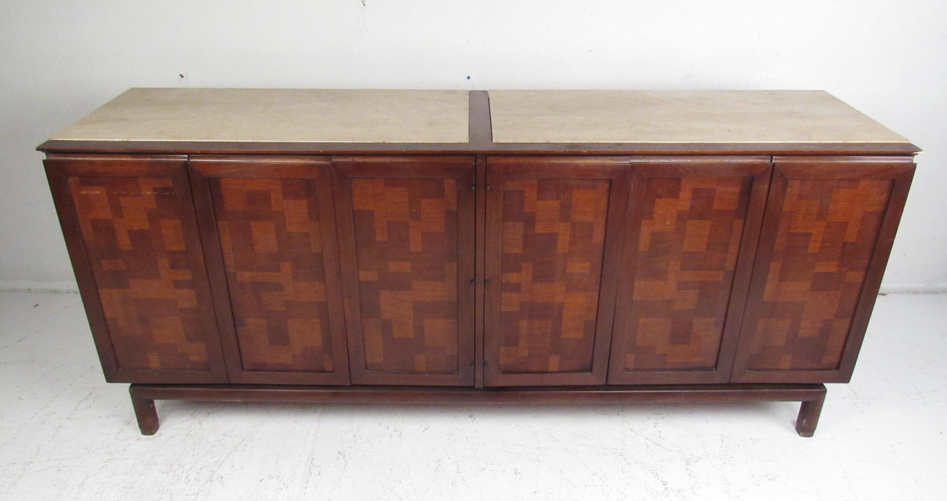 This beautiful vintage modern sideboard features an inlaid checker design on the front and a two-piece travertine top. An unusual design with retracting cabinet doors that open to unveil six hefty drawers providing plenty of room for storage. This