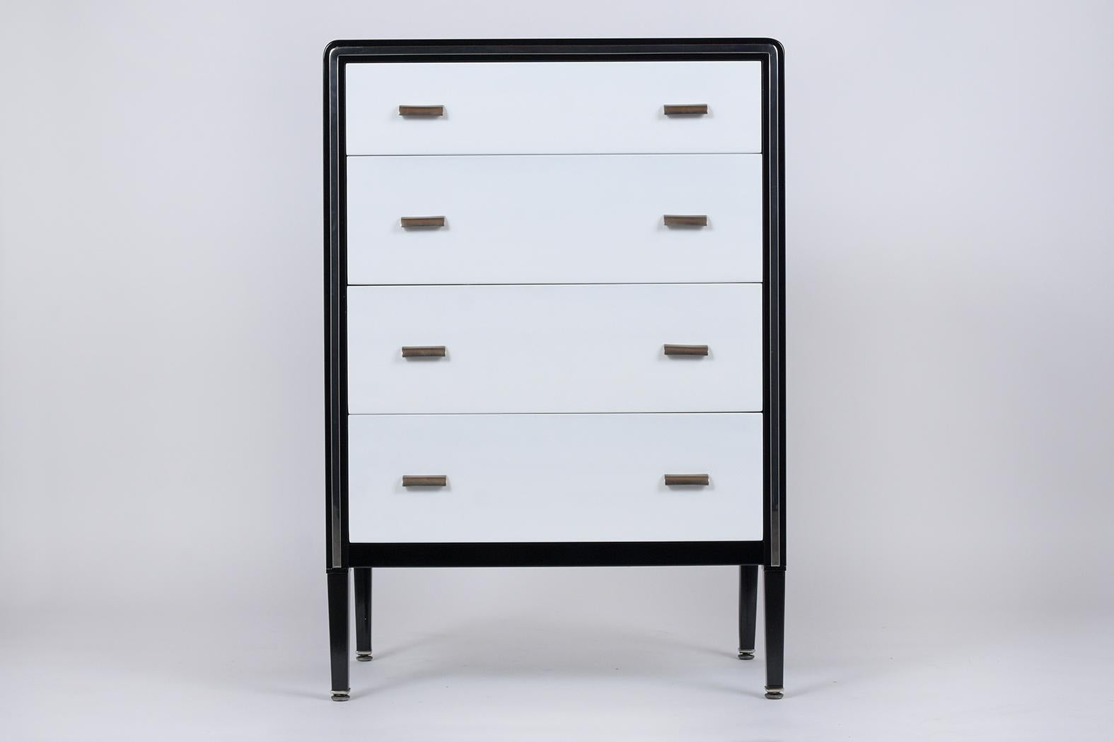 This modern chest of drawers by Simmons Company has been newly restored, is made out of metal and steel and is in great condition. This piece features a black and white color combination with a lacquered finish, flat chrome molding along the four