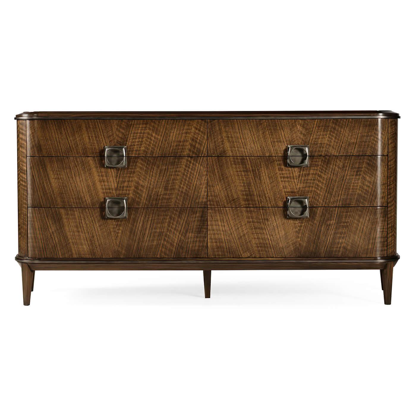 Comò in stile Mid-Century Modern, realizzato in noce con finitura laccata trasparente. Il piano è impiallacciato in noce con un motivo che ricorda la lavorazione della paglia. La ferramenta è fusa, immersa nell'acido e strofinata a mano per ottenere