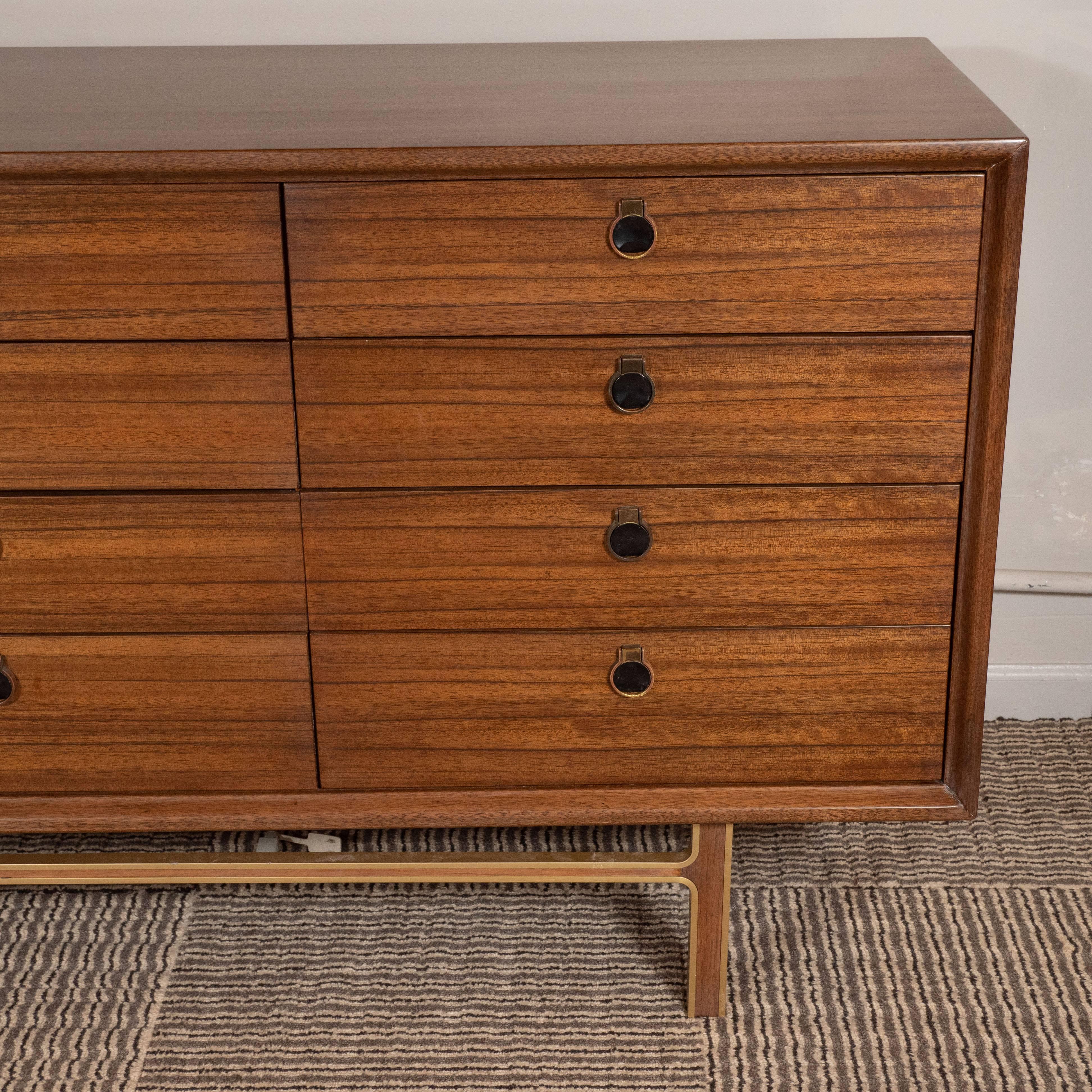 This elegant dresser was realized in the United States, circa 1960. It features a rectangular body with twelve drawers with circular brass pulls. Additionally, it offers straight rectangular legs adjoined at right angles by an apron of the same