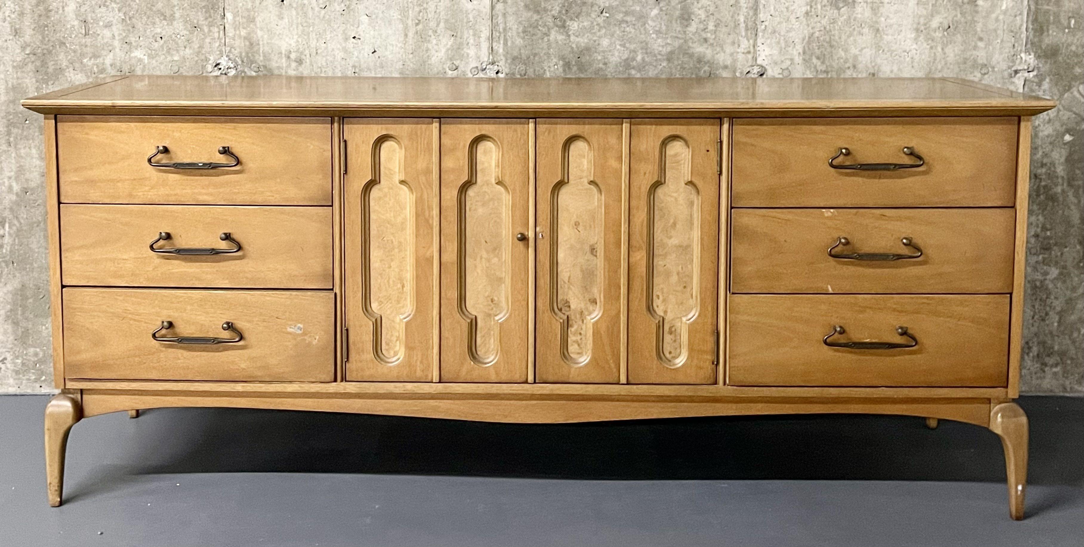 Mid-Century Modern dresser, sideboard by United Furniture Company. The case having two center doors flanked by three by three drawers with brass pulls. The case sitting on curved legs.


IgZ.