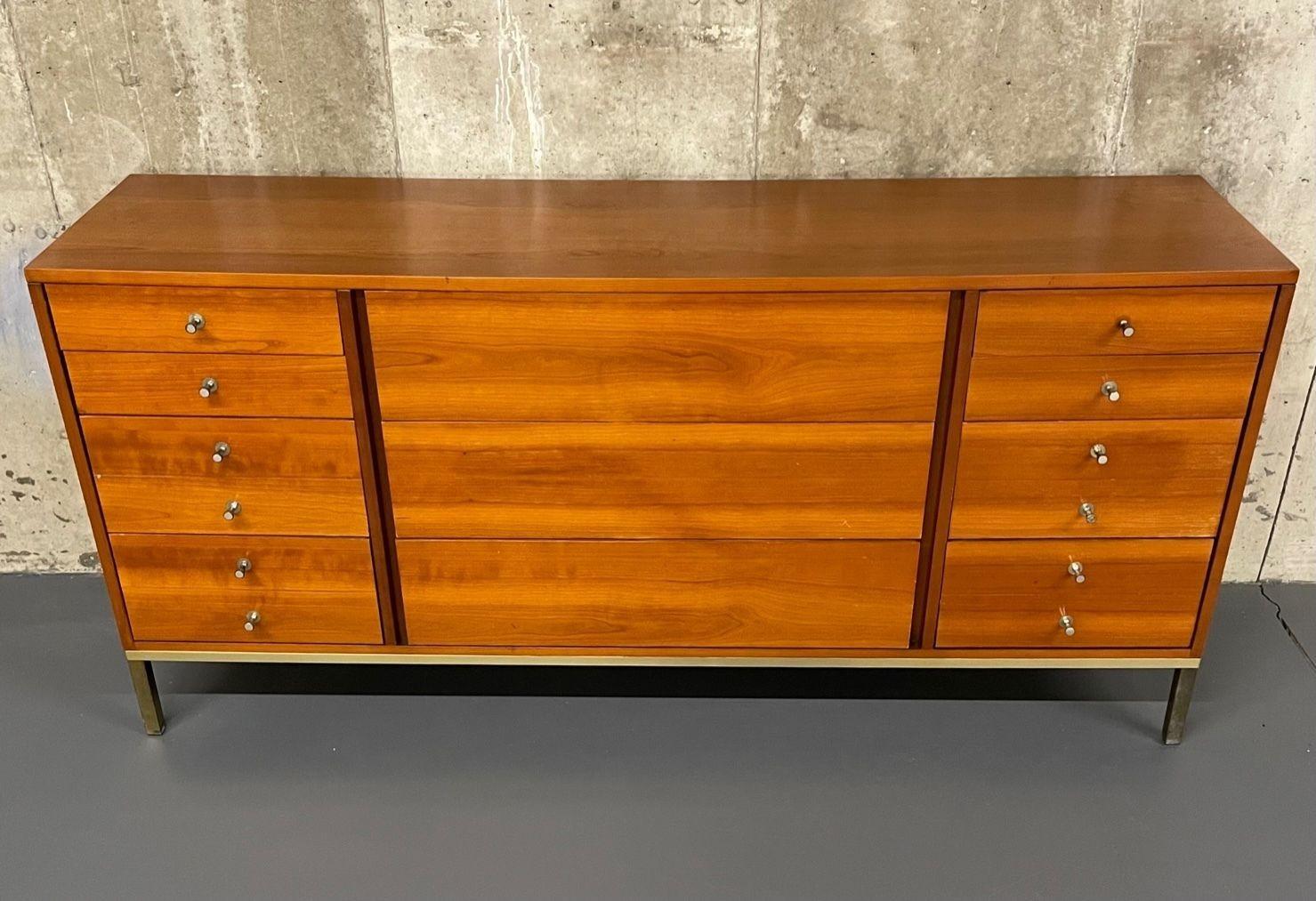 Mid-Century Modern dresser or sidebaord in the style of John Stuart, Metal Base
 
A finely constructed dresser or sideboard in the manner of John Stuart. Three center drawers flanked by four drawers supported by a rectangular metal base. Pulls on