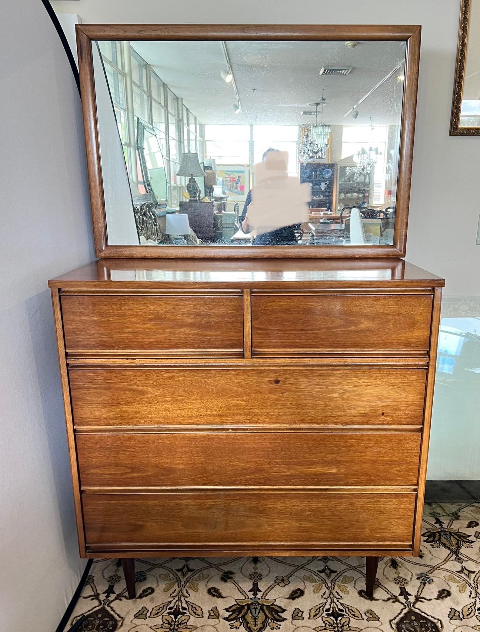 Mid century 2 pc walnut two over three drawer dresser with mirror. Clean sleek design by Dixie. The mirror dimensions are 42.5w by 28.5 tall and the dresser dimensions are above. Great scale and better lines. Why not own the good stuff.