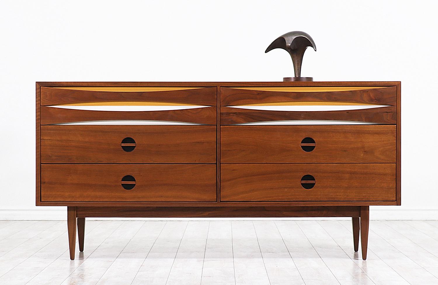 Exceptional Mid-Century Modern dresser designed and manufactured by West Michigan Furniture Co. in the United States, circa 1950s. This impressive dresser features a walnut wood case with lacquered finishes and a finely detailed grain pattern