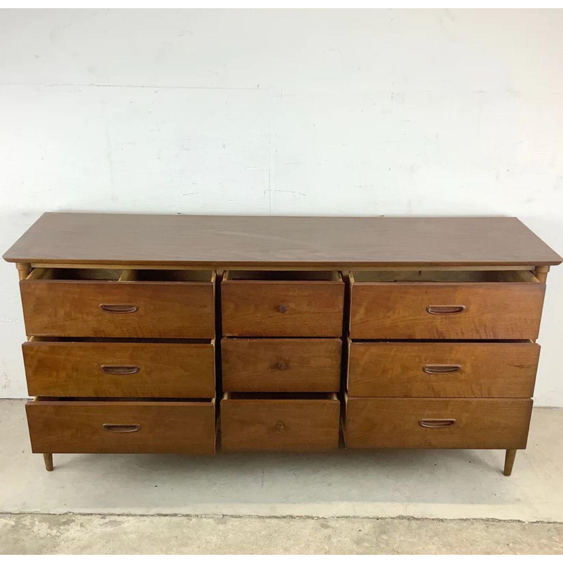 This stylish Lane Furniture bedroom dresser features midcentury design and nine spacious drawers in a striking walnut finish and a durable faux-wood laminate top. The details on the piece include dovetail joints, black trim, and curved drawer pulls