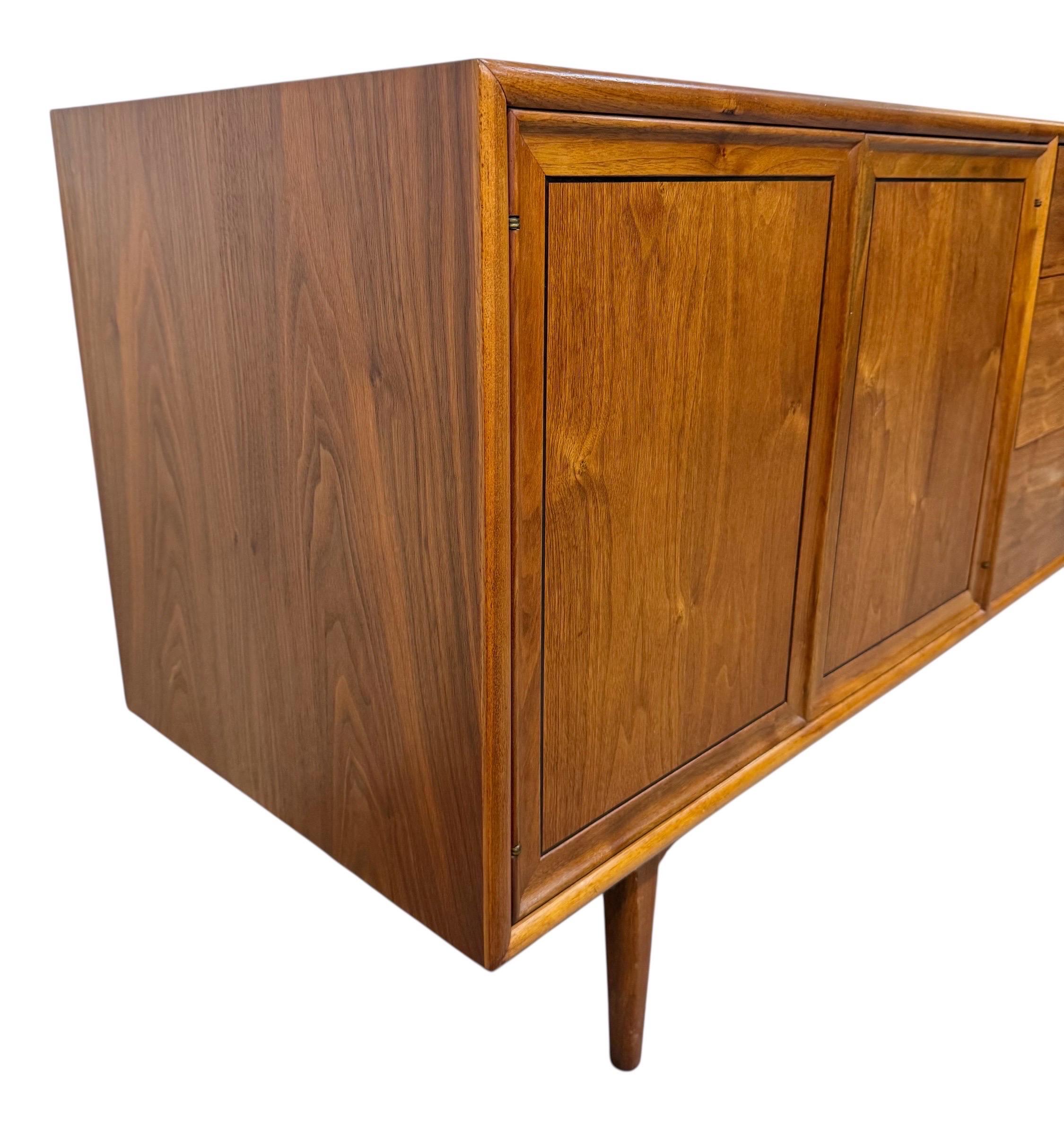 This listing is for a Mid-Century Modern Drexel Declaration 10-Drawer Walnut Dresser. Featuring a straight line design, two push button doors that open up to six hidden drawers, four larger drawers on the right side, original white milk glass knobs,