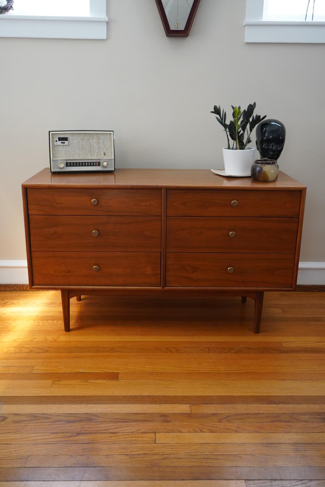 Elevate your bedroom with the timeless style of this Mid-Century Modern 6 drawer dresser from the Drexel Declaration line. The sleek and sophisticated design features clean lines and a warm wood finish that complements any decor. Each of the six