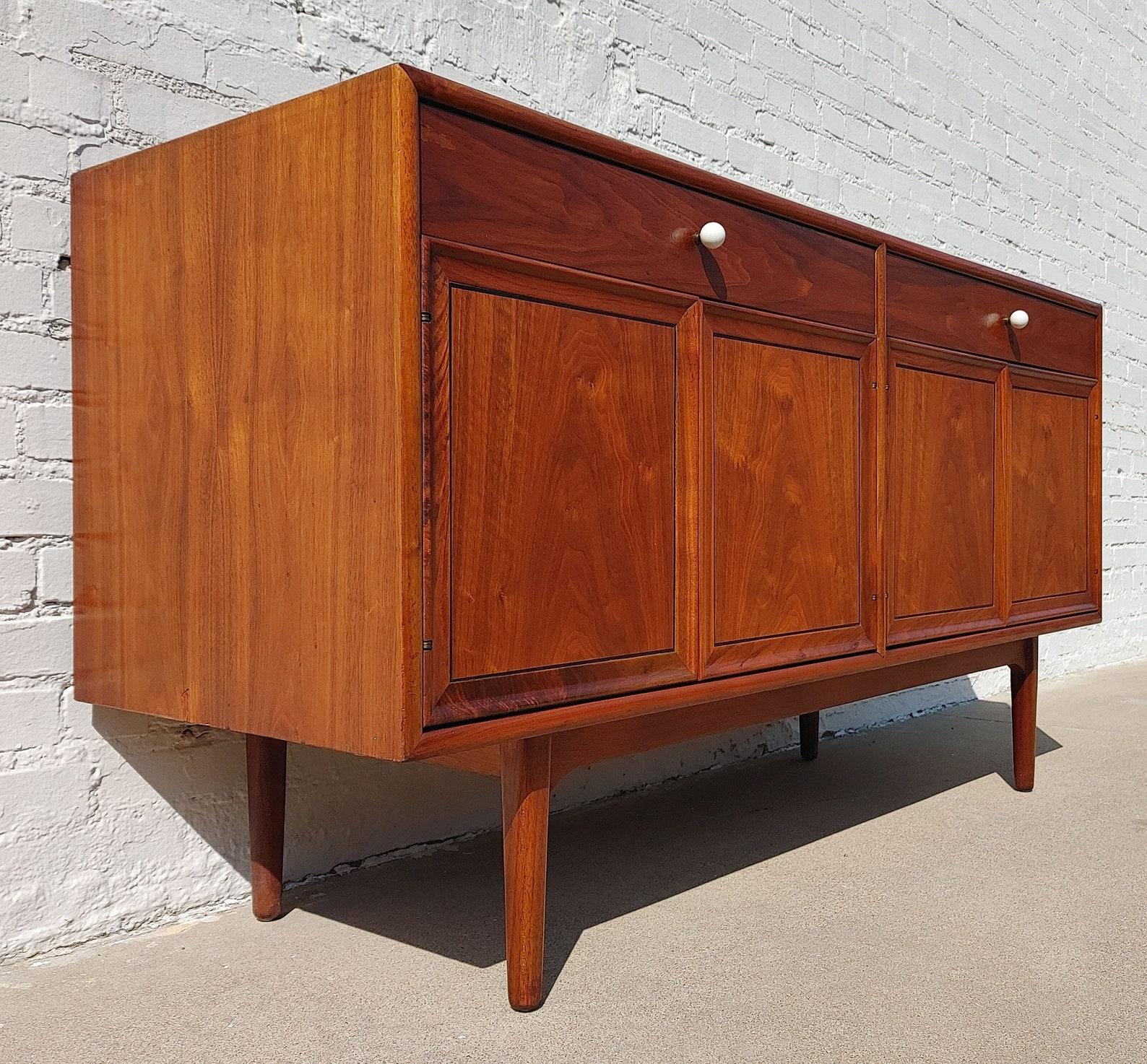 Mid Century Modern Drexel Declaration Buffet

Above average vintage condition and structurally sound. Top has been refinished and does not have original factory finish.
Back sides have a couple areas where patched. Both bottom cabinets have