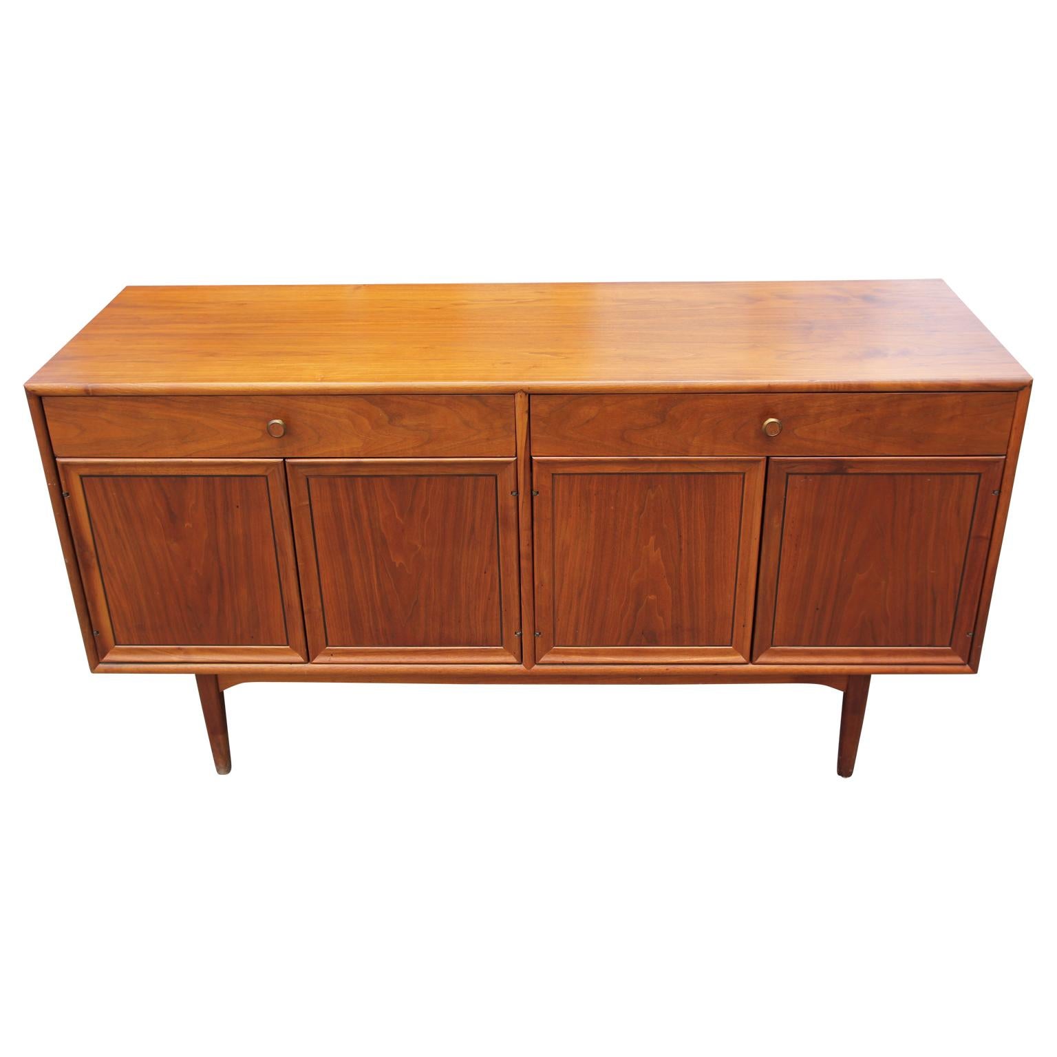 Mid-Century Modern buffet or sideboard made by Drexel. The buffet features two pull out drawers and two swing out door revealing deep storage space. On the inside of the drawer is the makers stamp.