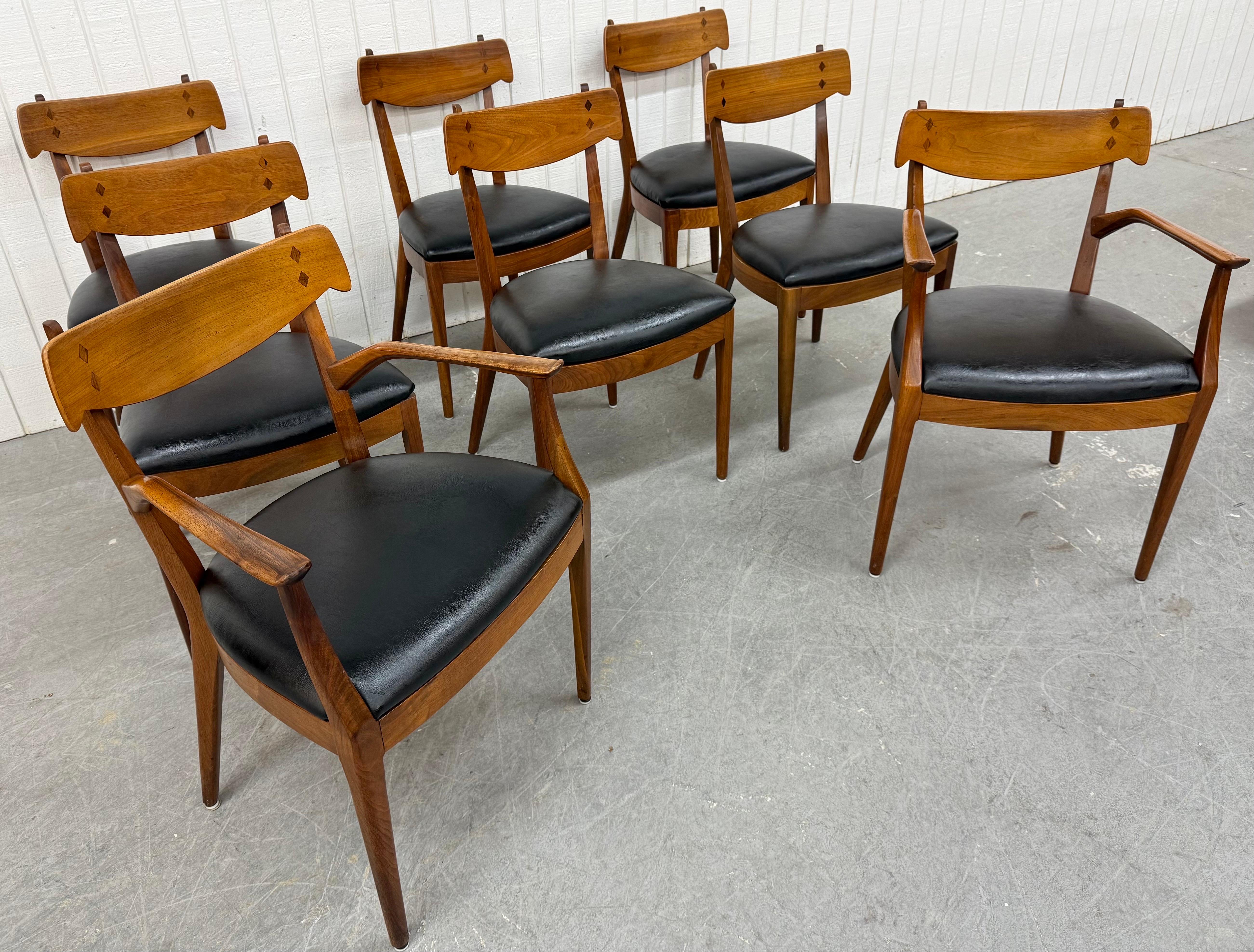 This listing is for a set of eight Mid-Century Modern Drexel Declaration Walnut Dining Chairs. Featuring two bent wood arm chairs, six side chairs, wooden backrests with diamond inlay, new black vinyl upholstery, and a beautiful walnut finish. This