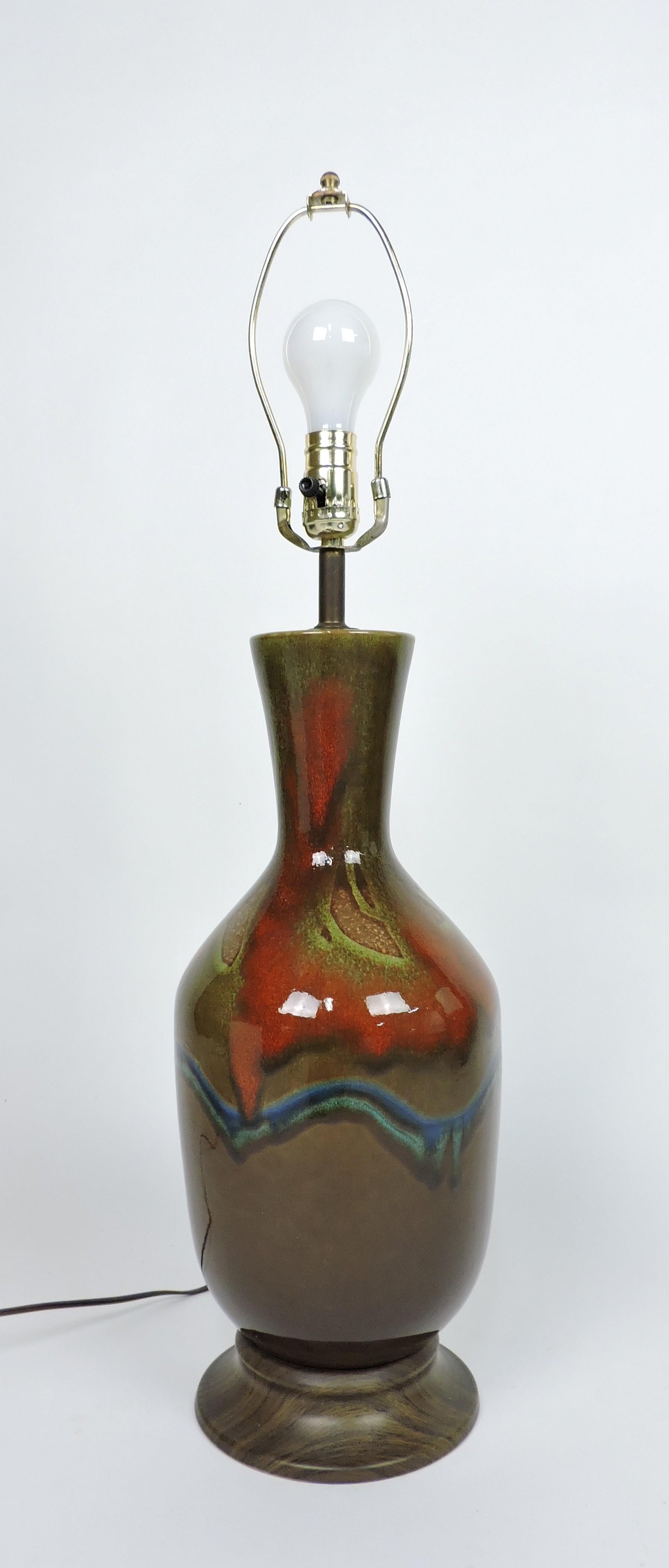 Beautiful ceramic drip glaze table lamp.  This lamp has multi-colored swirled drips on a brown background and a faux wood metal base.  It has all new wiring and takes a 3-way bulb. The shade is not included.