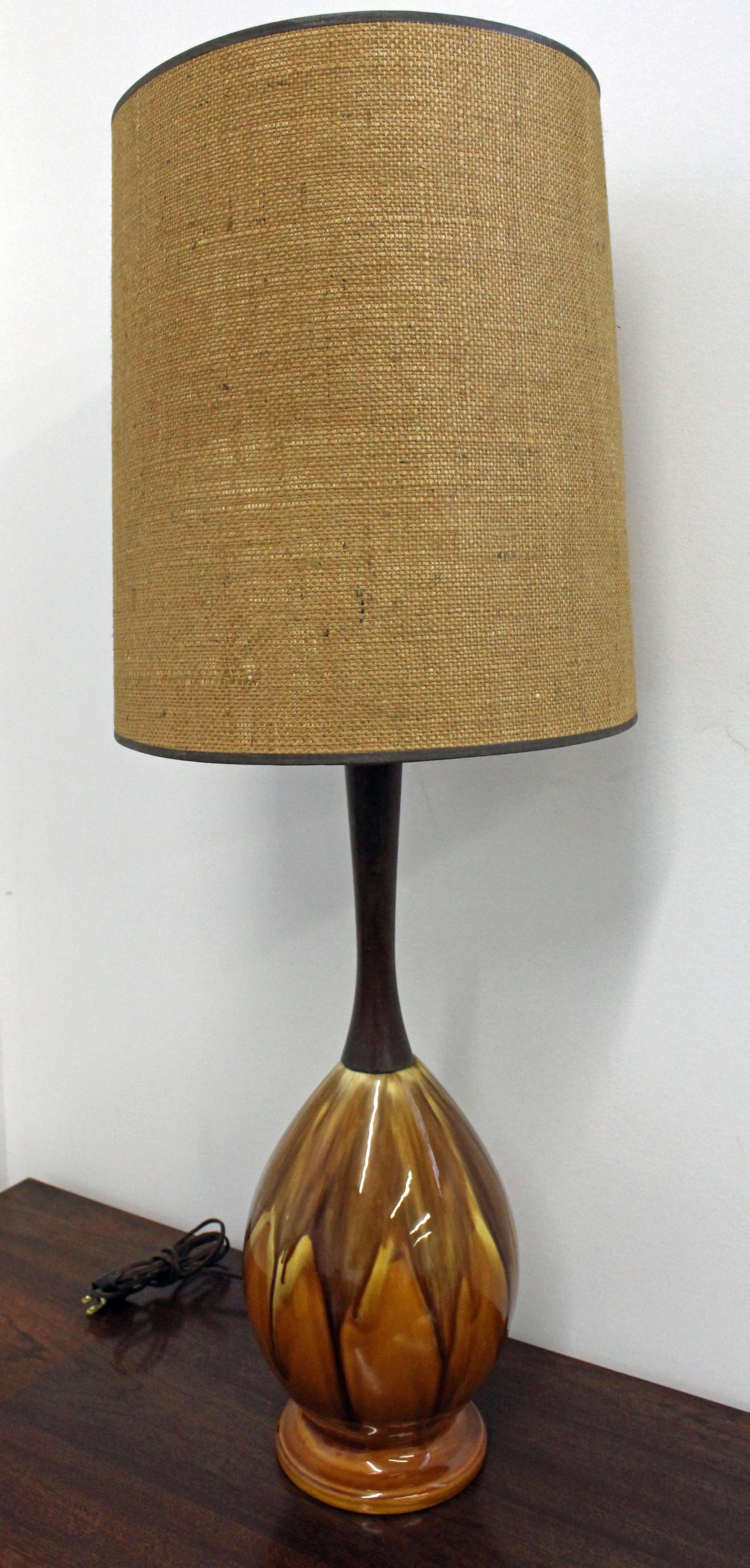 Offered is a retro vintage ceramic drip-glazed and walnut table lamp. The lamp shade shown is not included (display purposes only). It is in good, working condition, shows minor age wear (light surface scratches on wood, lighting works-see