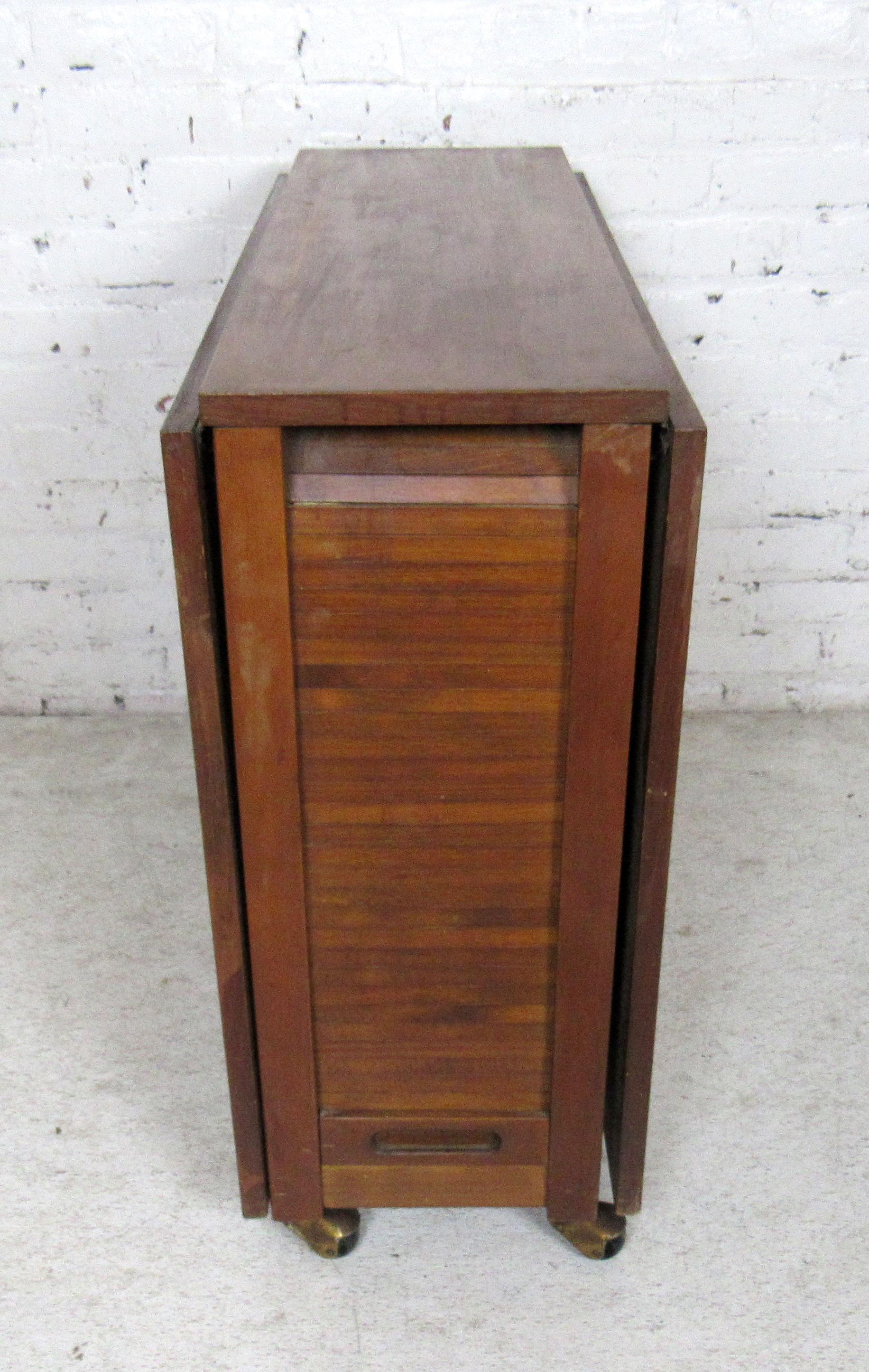 Vintage modern drop-leaf table with four wooden slat chairs.

Table: 13