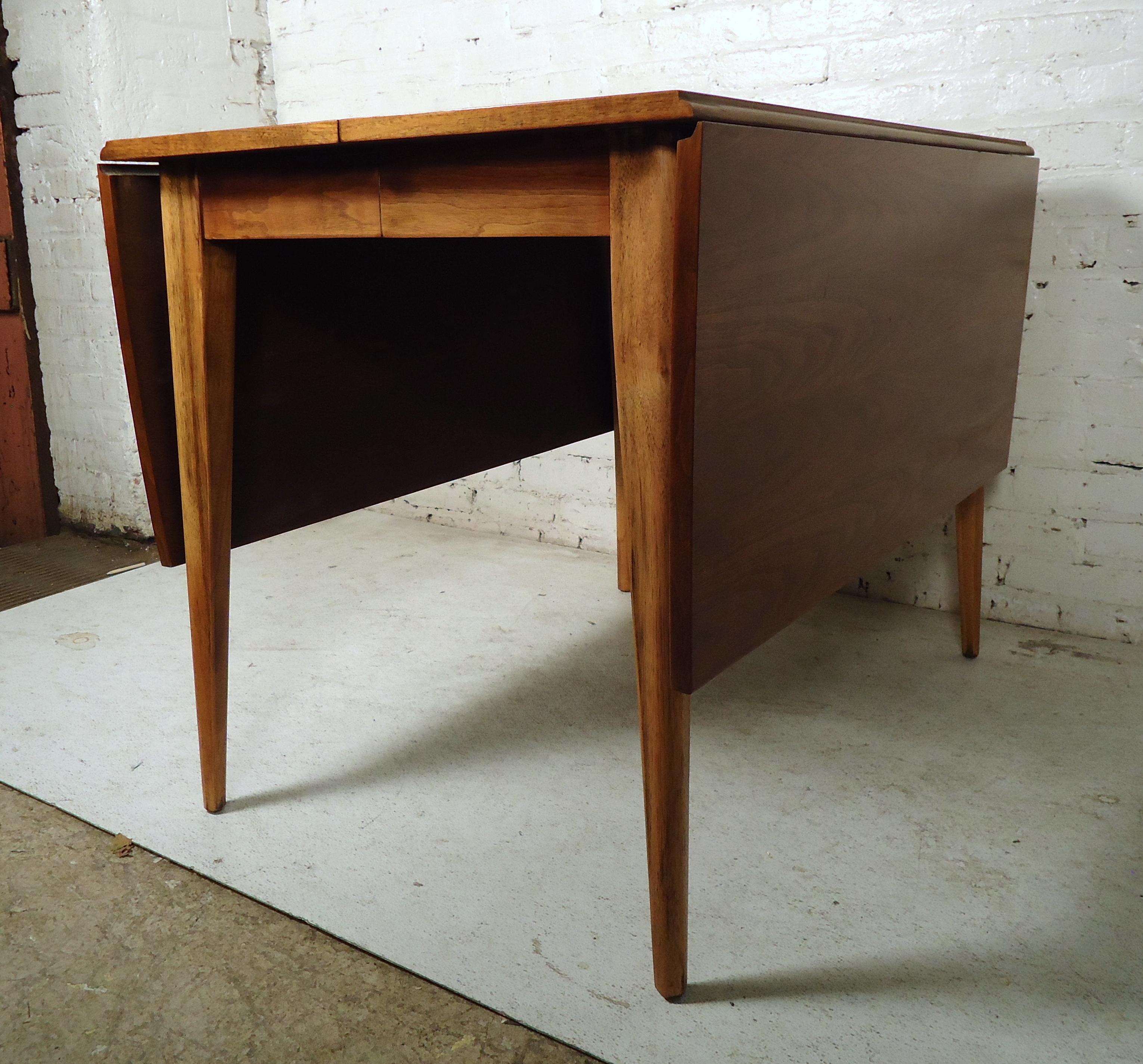 Vintage modern drop-leaf table featuring rich walnut wood grain, two leaves expand the table from 28