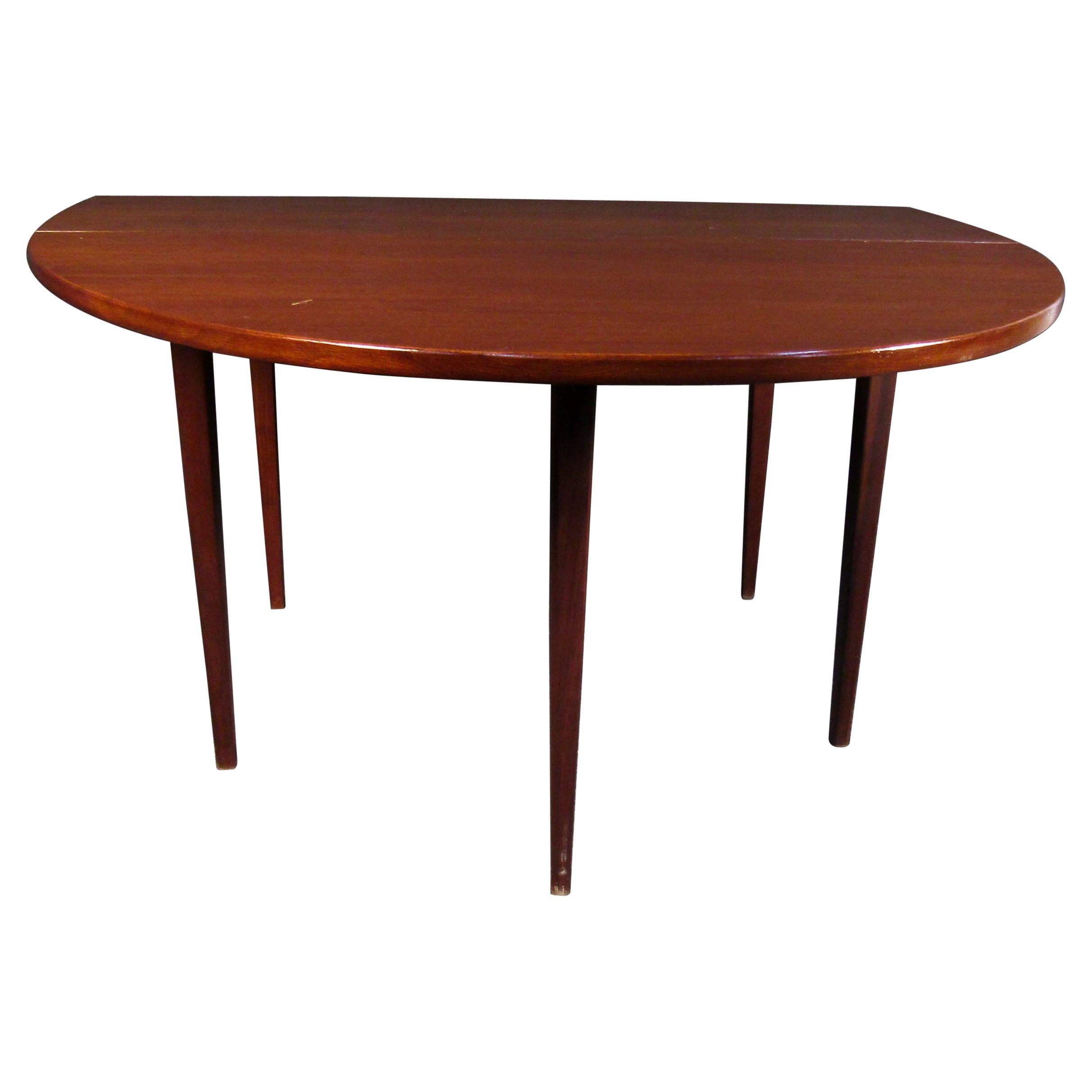 Beautiful rich woodgrain is paired with a functional drop leaf design in this Mid-Century Modern walnut table. Please confirm item location with seller (NY/NJ).