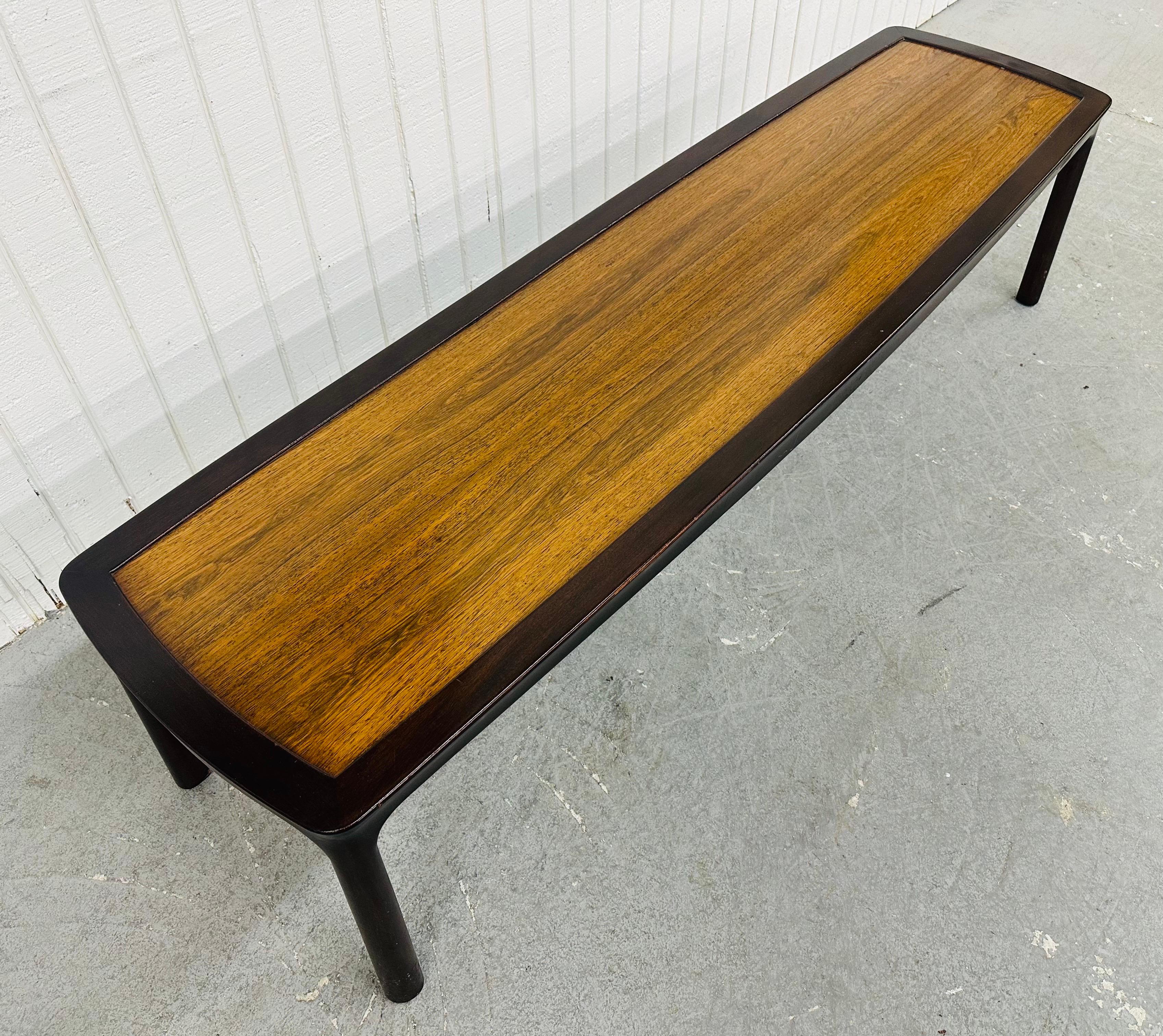Cette annonce concerne une table basse en bois de rose Dunbar, de style moderne du milieu du siècle. Elle se compose d'un long plateau rectangulaire en bois de rose et de quatre pieds modernes en finition bois foncé. Il s'agit d'une combinaison