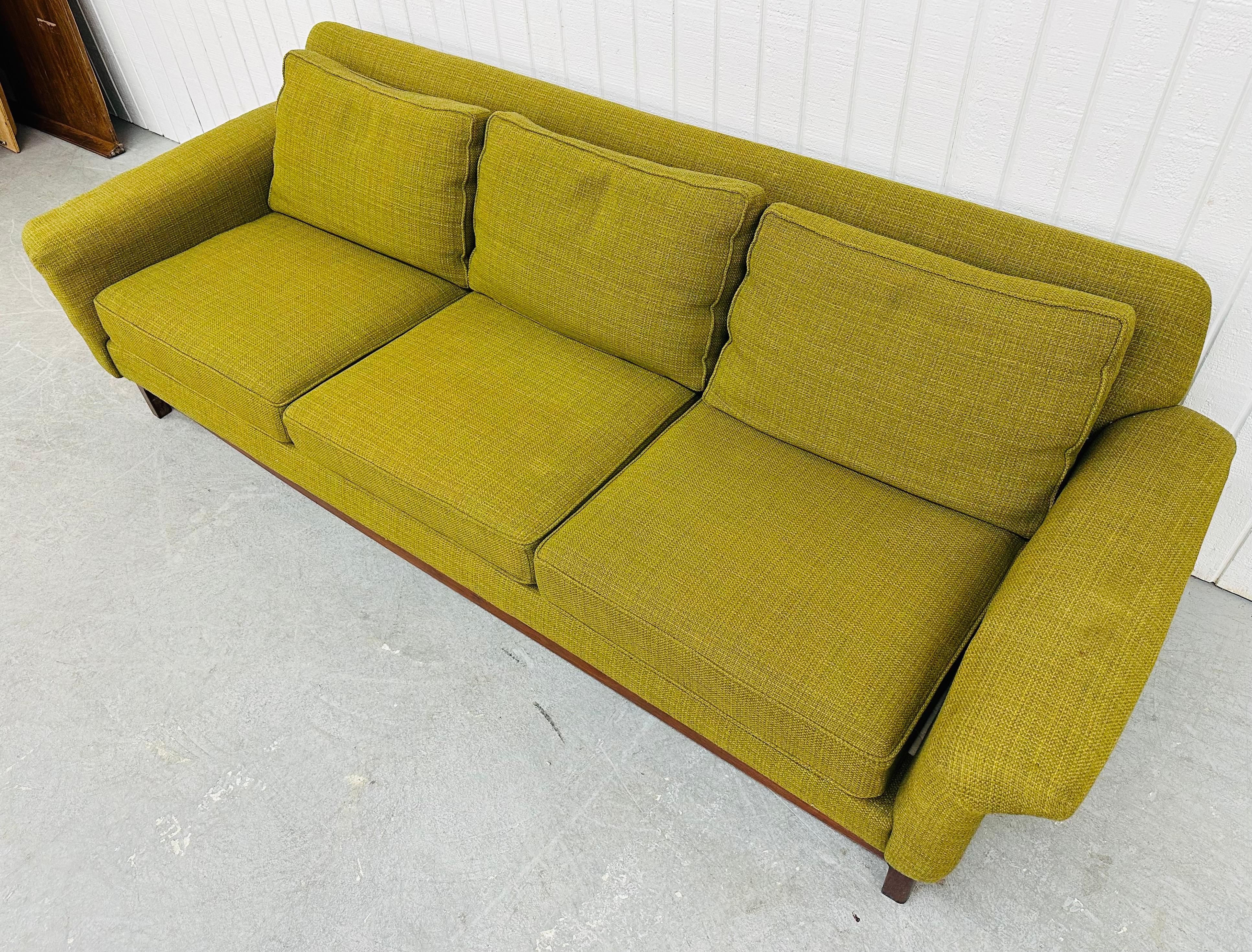 This listing is for a Mid-Century Modern Dux Sofa. Featuring a straight line design, original green upholstery, walnut legs, curved arm rests, and original DUX tag. This is an exceptional combination of quality and design by DUX.