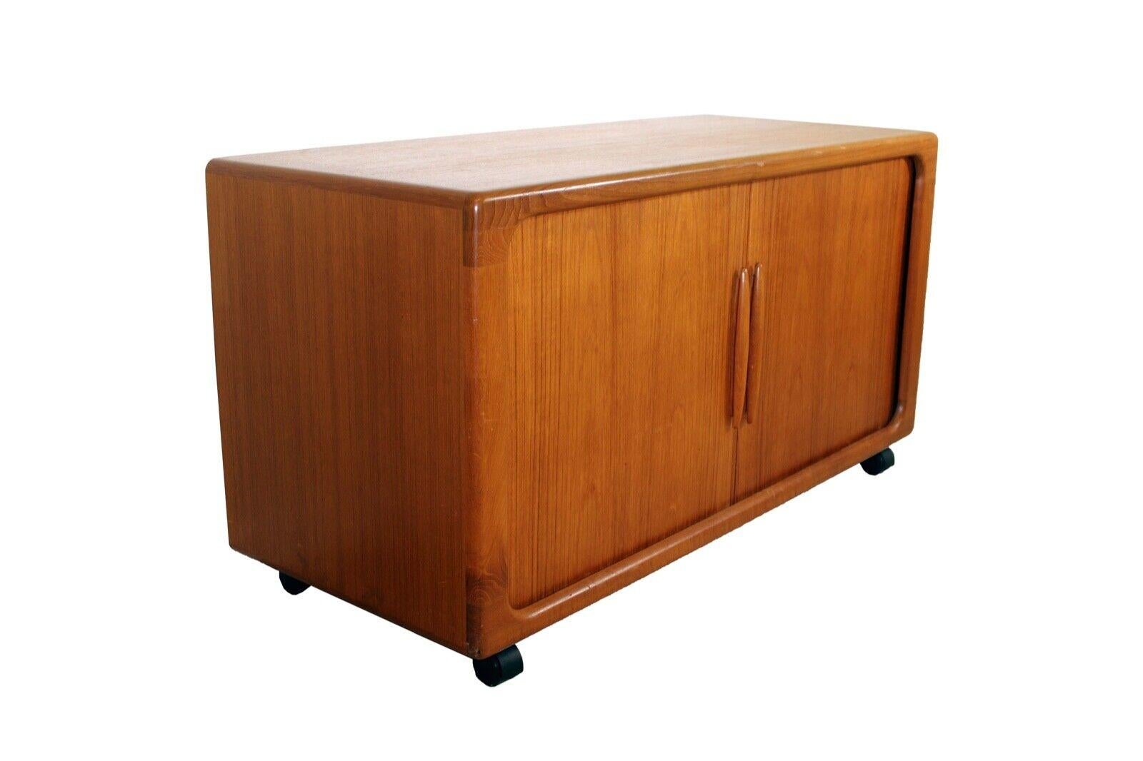 A stunning teak media console/credenza created by Dyrlund in the 1960s. Sleek organic shaping and sliding doors that disappear when credenza is opened. In very good vintage condition. Dimensions: 49