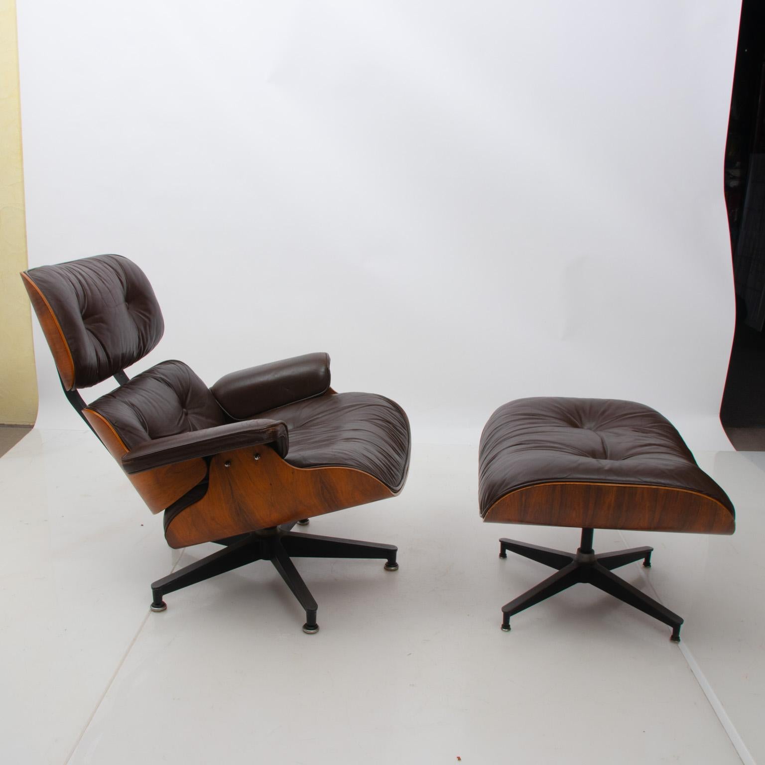Vintage Eames rosewood upholstered chair and ottoman on aluminum legs, circa 1970s. The pieces also feature chocolate brown leather and tufted buttons. Maker's label is underneath. Please note of wear to consistent with age to the leather upholstery