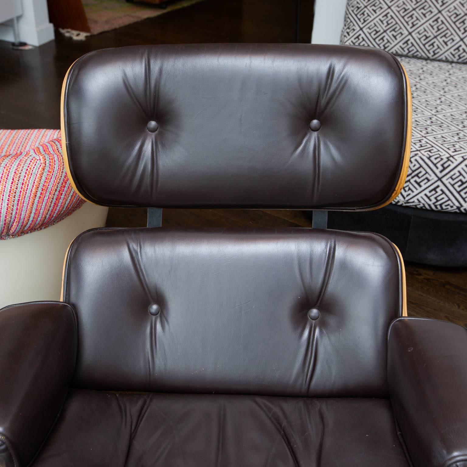 Most likely made by Selig in the 1970s, this good quality replica of the iconic Eames lounge chair and ottoman in chocolate brown leather is of a higher quality than the Plycraft ones of the same era. Has rivets in back's highest section where