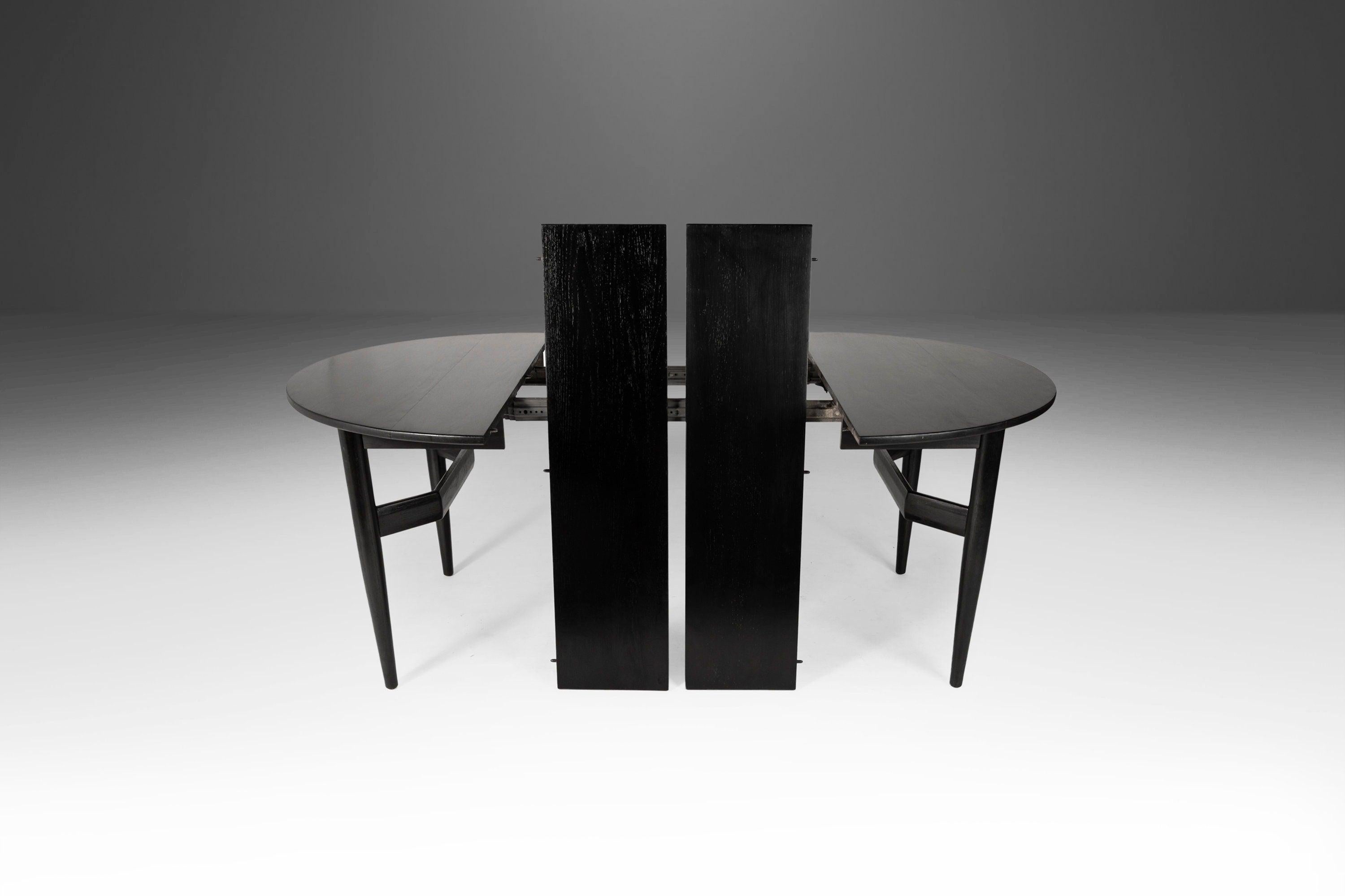 As functional as it is visually alluring this extraordinary dining table, ebonized in a silky jet-black stain, is ready for your space. Constructed of walnut, with spectacular angular legs and featuring two easily removeable leaves this table is