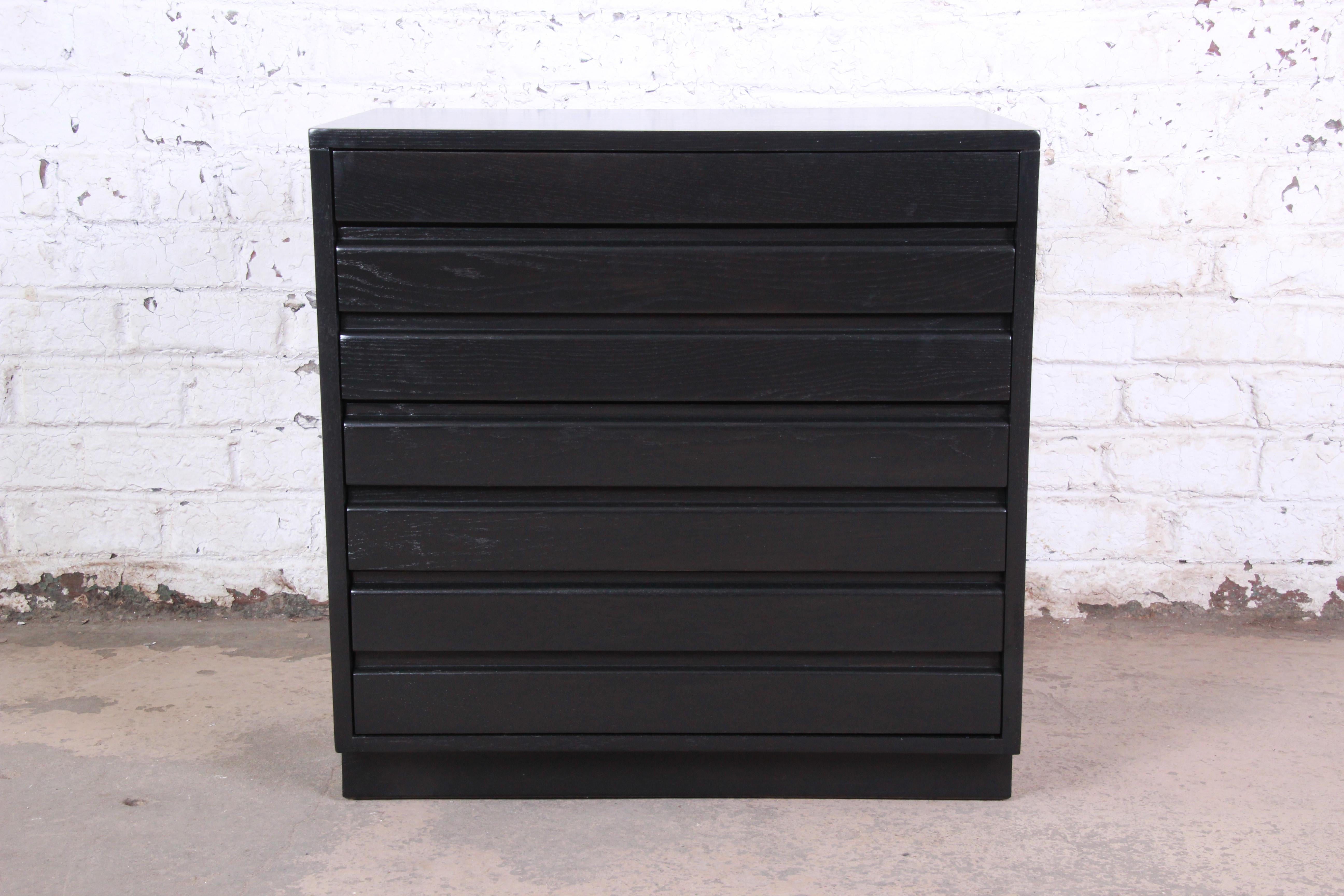 A gorgeous ebonized chest of drawers by Sligh Furniture of Grand Rapids. The dresser features beautiful wood grain with a newly ebonized finish and sleek midcentury design. It offers good storage with four dovetailed drawers. The top three drawers