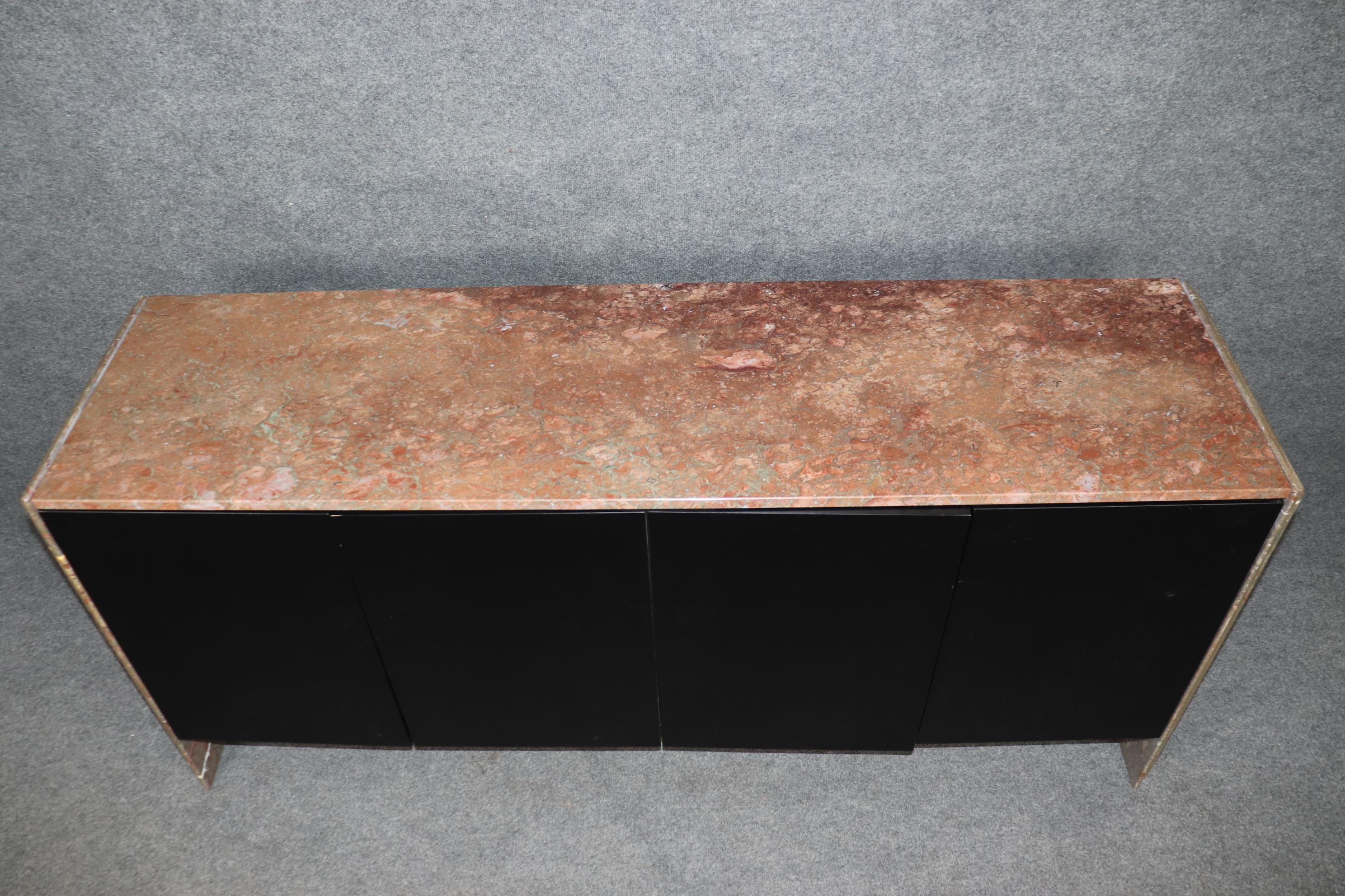 This is a unique and gorgeous sideboard with both a marble top and marble sides. The piece is heavy and substantial and was made custom for a discriminating buyer. The piece is in good condition with ebonized black lacquer and gorgeous breccia