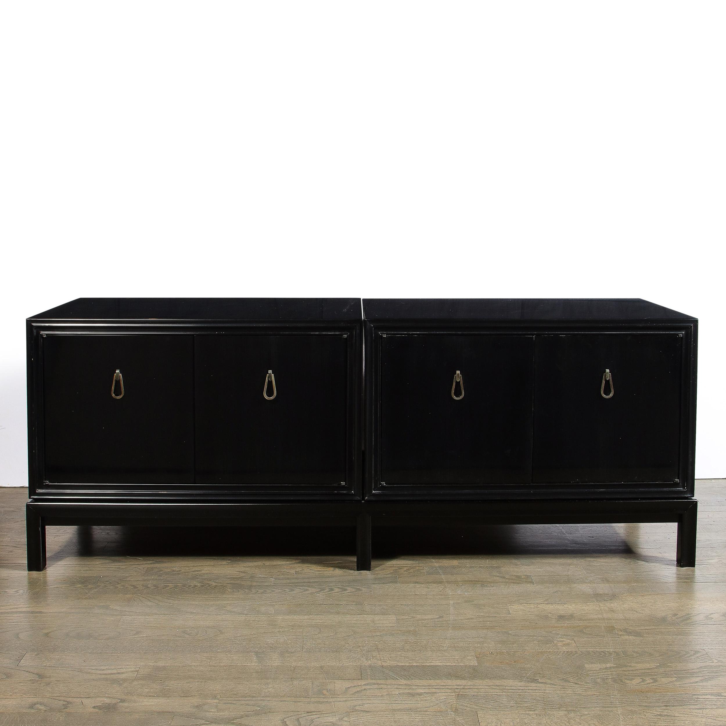 This stunning Mid-Century Modern cabinet was realized by the illustrious designer Renzo Rutili in Italy circa 1950. It features two volumetric rectangular ebonzed walnut bodies that adjoin to create a single elongated form replete with teardrop form