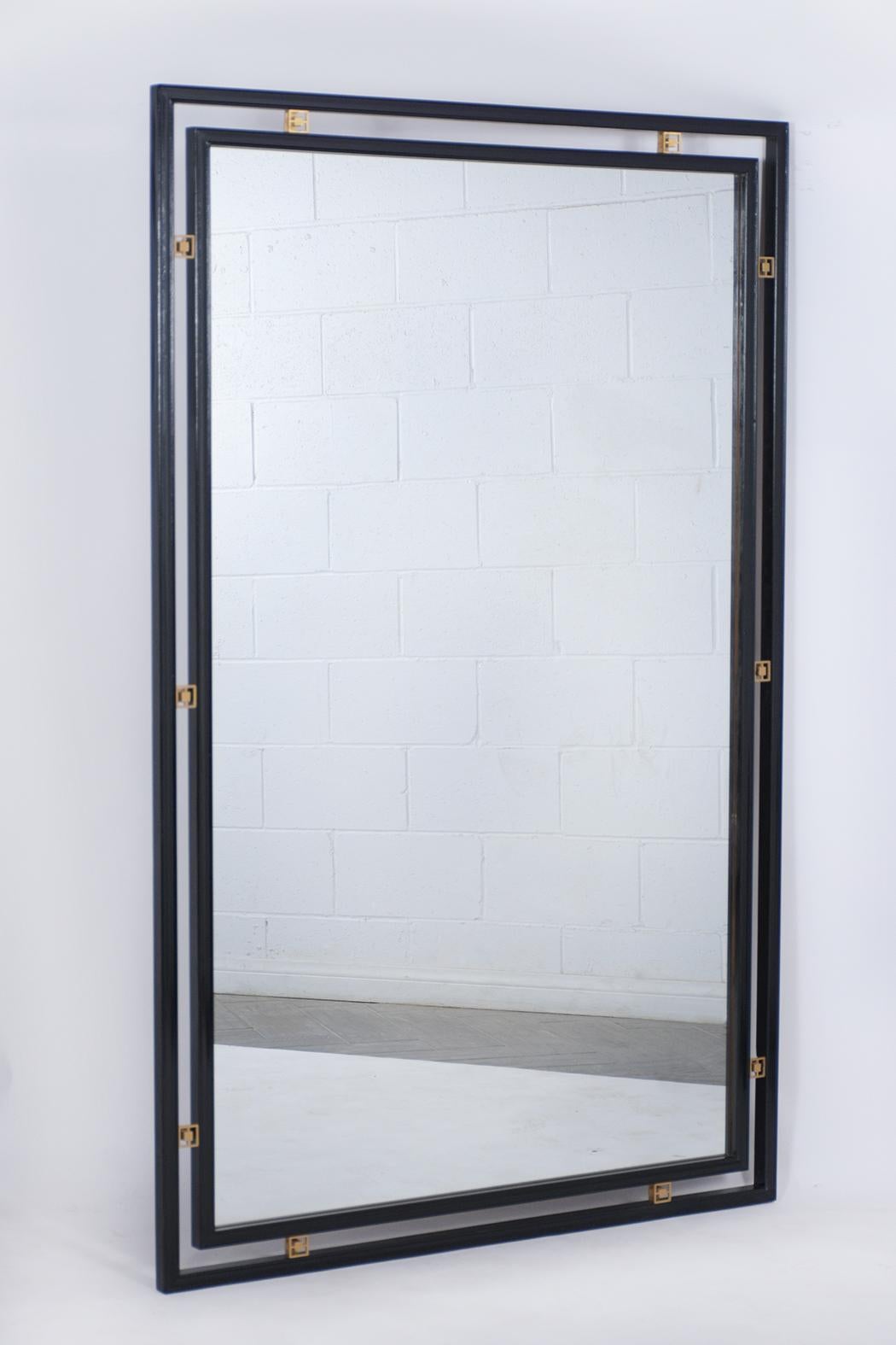 This vintage midcentury wall mirror is in great condition, comes with its original mirror glass that's fully reflective, has a new ebonized lacquered finish, and comes with decorative brass accents around the mirror. This 1960 ebonized floor mirror