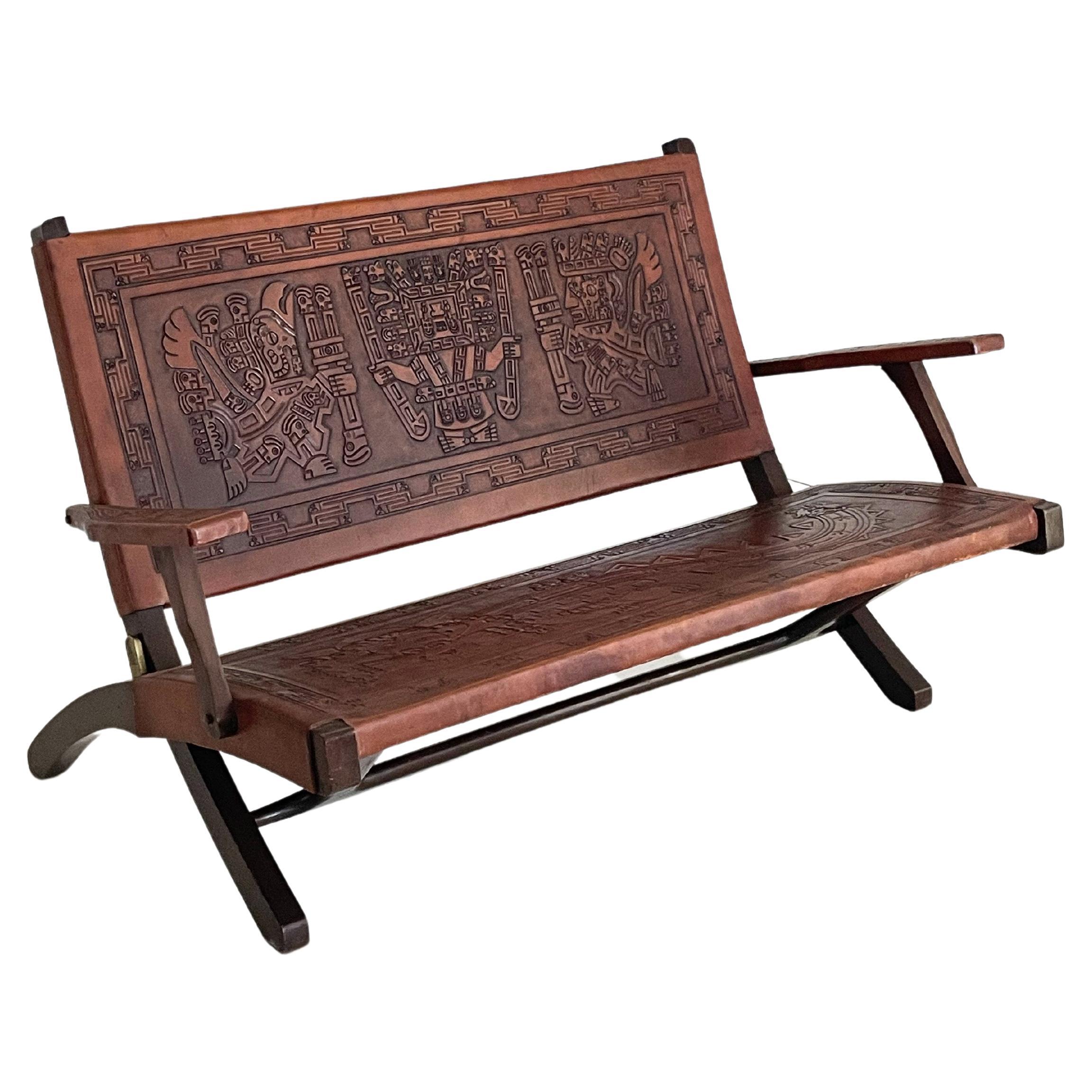 Angel Pazmino for Muebles de Estilo Tooled leather folding bench circa 1965, Ecuador, with mahogany bench, instrumental leather pattern of Mayan figures Condition: good, leather, shows general slight wear appropriate to age and normal use, small