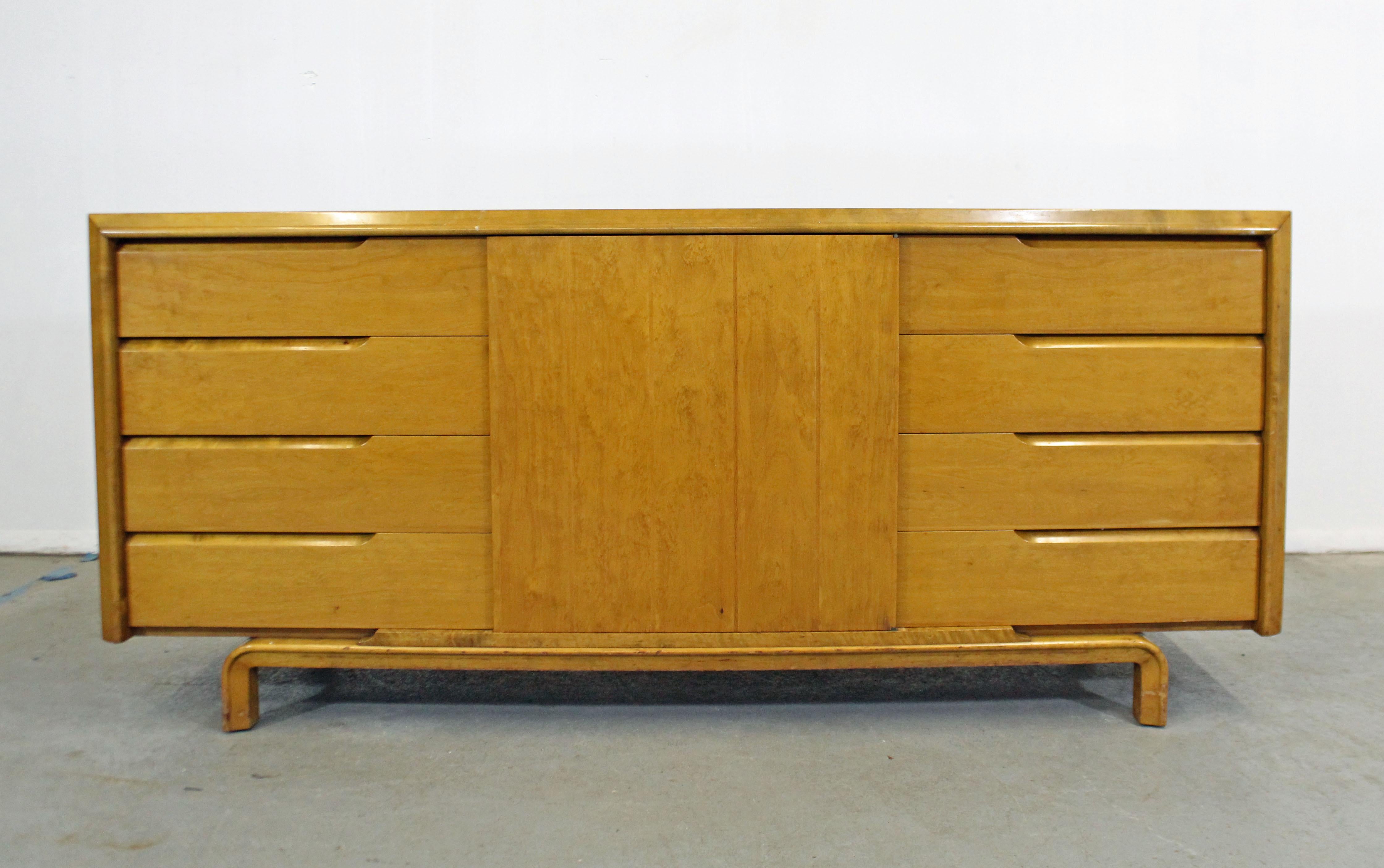 Offered is a beautiful vintage midcentury credenza designed by American designer Edmond J. Spence. Has ample storage space with four dovetailed drawers on each side and a middle door with one drawer and space for storage inside. One top drawer has